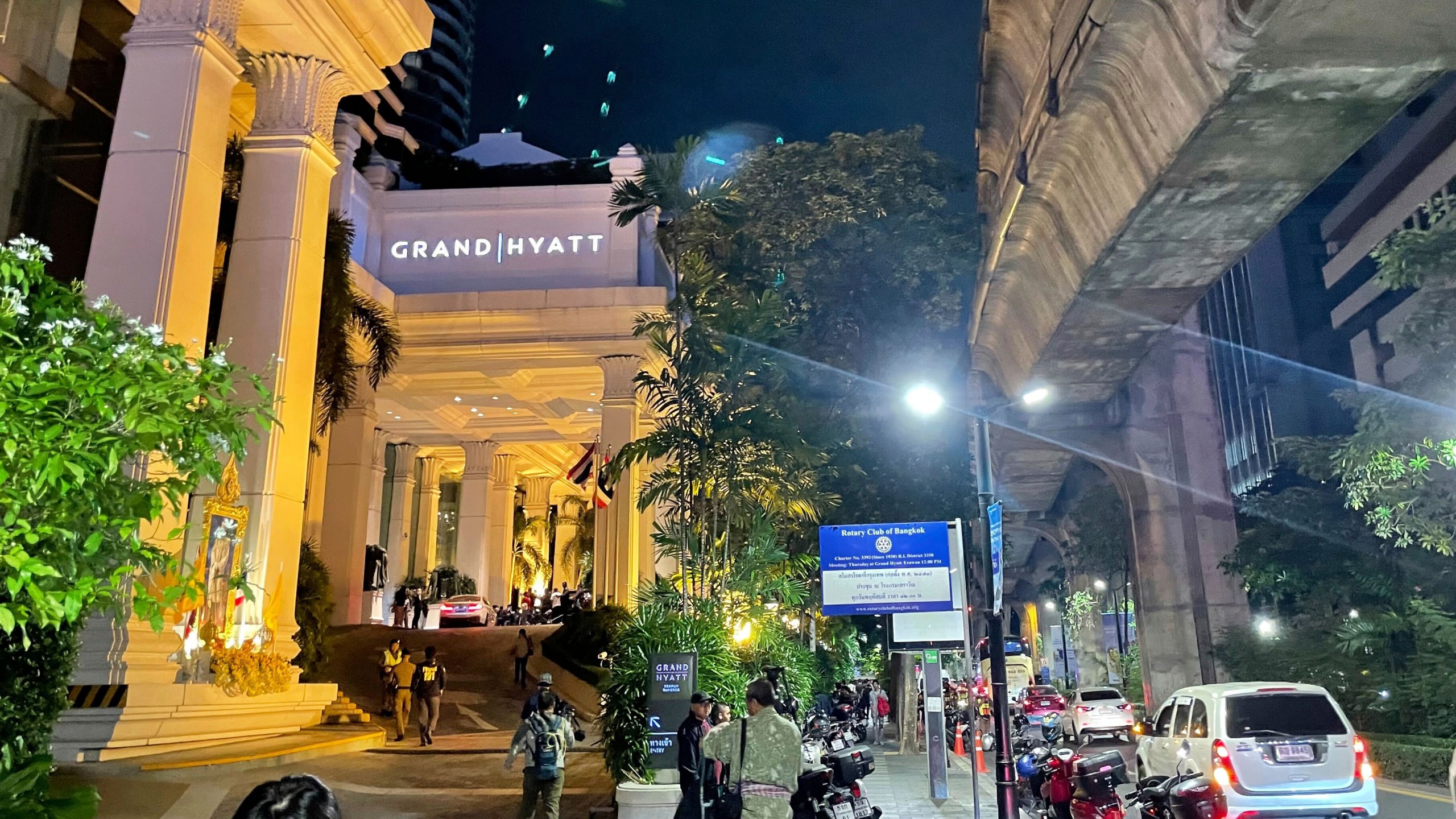 People walk outside a hotel where a number of people were found dead in Bangkok, Thailand, Tuesday, July 16, 2024. (AP Photo/Napat Kongsawad)