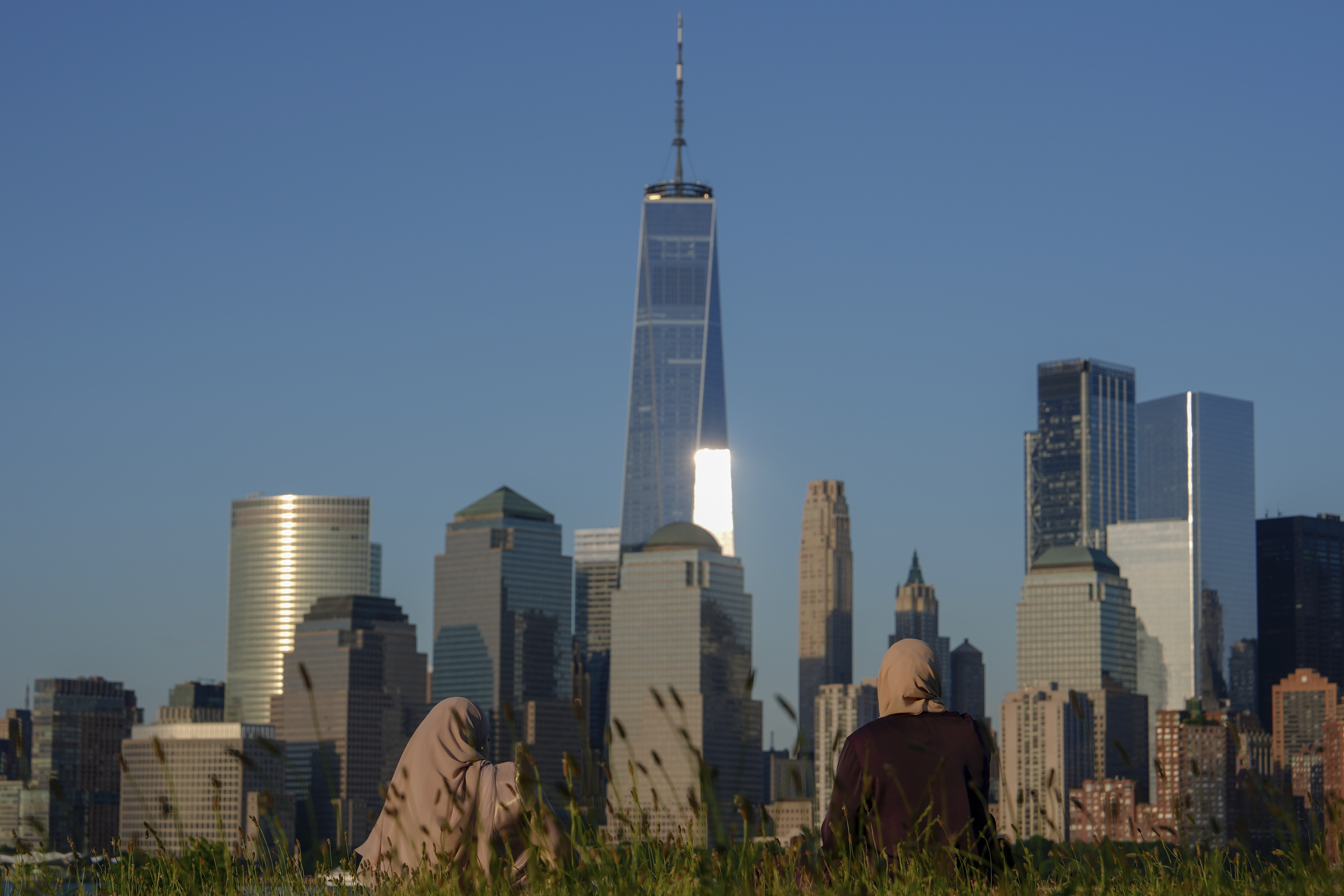 FILE - People look out at the New York City skyline at sunset, Sunday, June 16, 2024, in Jersey City, N.J. A meteor streaked across the New York City skyline before disintegrating over nearby New Jersey, according to NASA. William Cooke, the head of the space agency's Meteoroid Environments Office, said the fireball was first sighted at an altitude of 51 miles (82 kilometers) above Manhattan at around 11:17 a.m. Tuesday, Juky 14, 2024. (AP Photo/Julia Nikhinson, File)