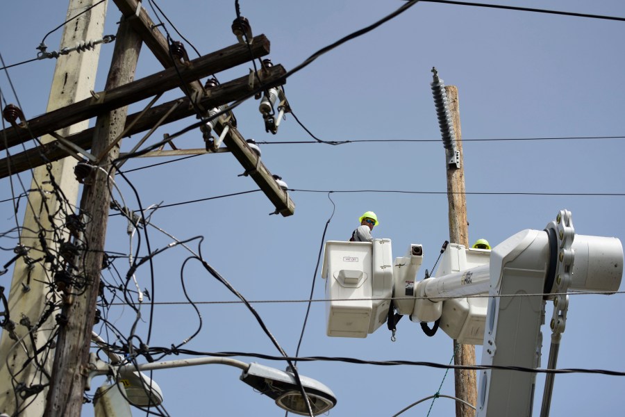 FILE - A brigade from the Electric Power Authority repairs distribution lines damaged by Hurricane Maria in the Cantera community of San Juan, Puerto Rico, Oct. 19, 2017. A federal judge overseeing a drawn-out debt-restructuring process for the power company ordered all parties to mediation on Wednesday, July 10, in the latest attempt to break an impasse that has sparked widespread anger and frustration. (AP Photo/Carlos Giusti, File)