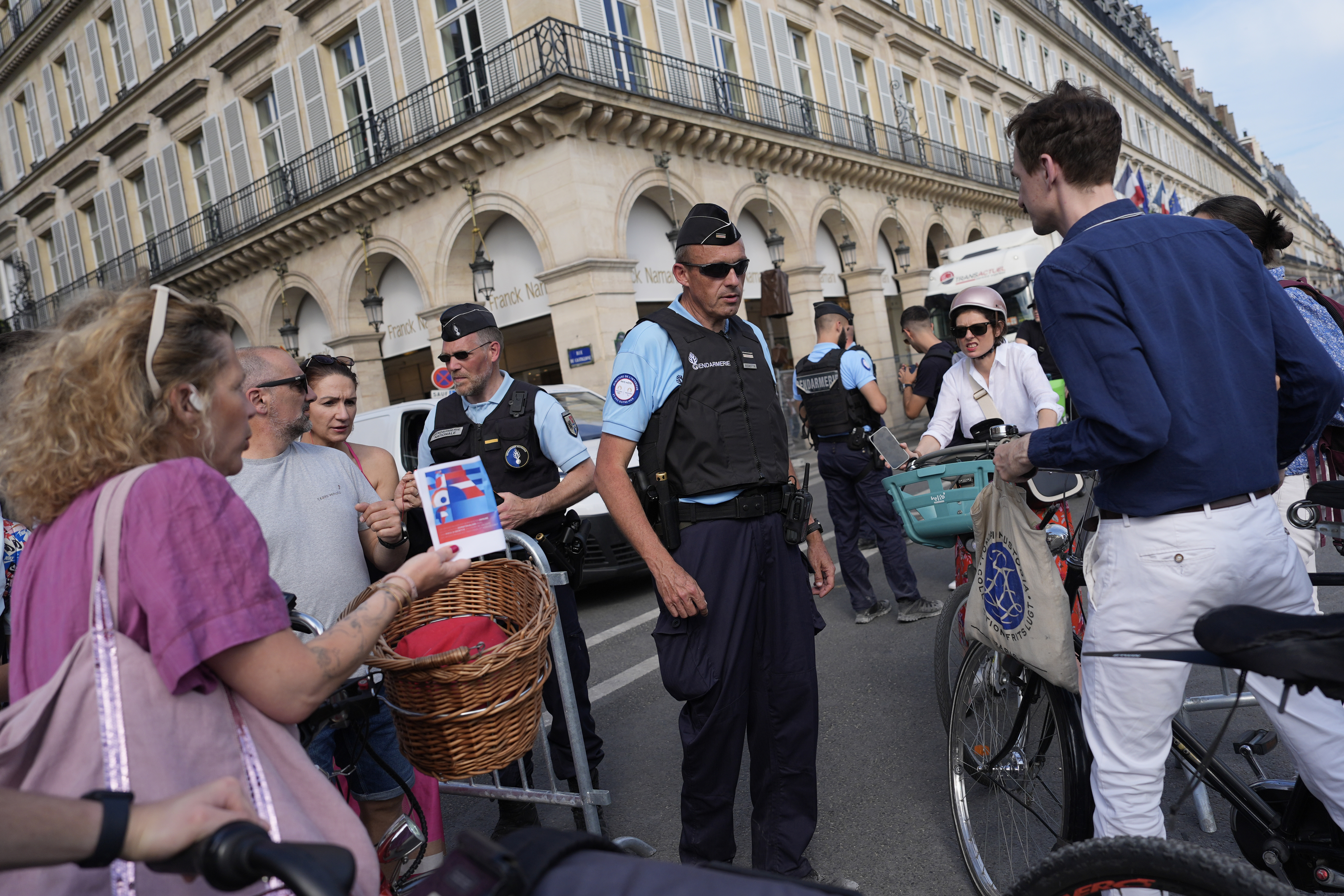 Police officers check authorizations at a check point Thursday, July 18, 2024 in Paris. A special kind of iron curtain came down across central Paris on Thursday, with the beginning of an Olympic anti-terrorism perimeter along the banks of the River Seine sealing off a kilometers-long (miles-long) area to Parisians and tourists who hadn't applied in advance for a pass. (AP Photo/David Goldman)