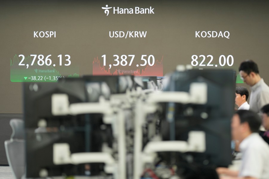 Currency traders watch computer monitors near the screens showing the Korea Composite Stock Price Index (KOSPI), left, and the foreign exchange rate between U.S. dollar and South Korean won at a foreign exchange dealing room in Seoul, South Korea, Friday, July 19, 2024. (AP Photo/Lee Jin-man)