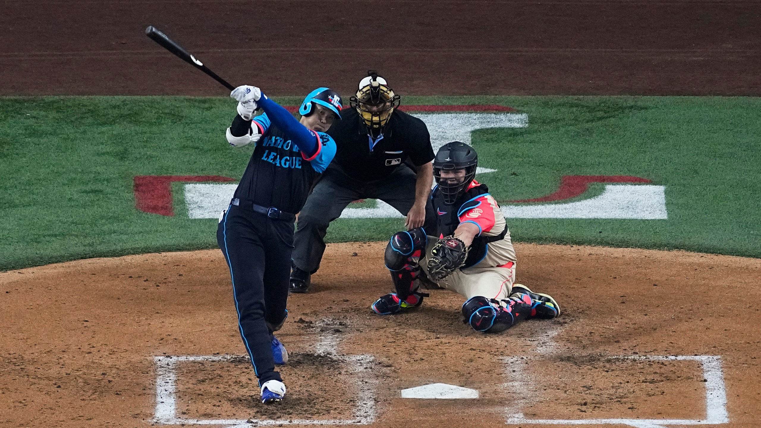 National League's Shohei Ohtani, of the Los Angeles Dodgers, hits a home run during the third inning of the MLB All-Star baseball game, Tuesday, July 16, 2024, in Arlington, Texas. Jurickson Profar, of the San Diego Padres, and Ketel Marte, of the Arizona Diamondbacks, also scored. (AP Photo/Tony Gutierrez)