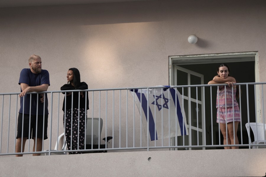 People watch from their balcony as Israeli police investigate the scene of a deadly explosion in Tel Aviv, Israel, Friday, July 19, 2024.(AP Photo/Oded Balilty)