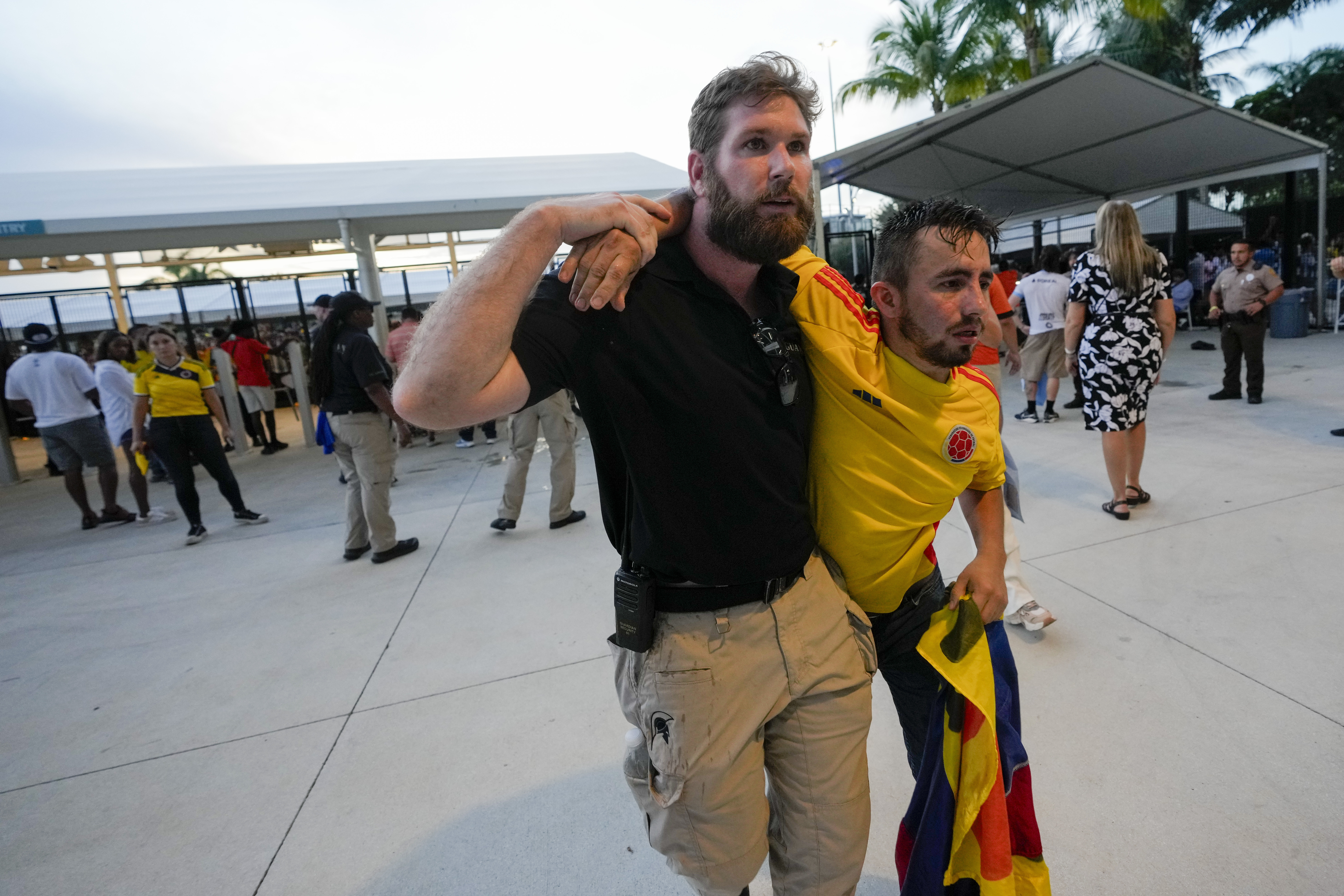 A security agent assist a fan who was waiting to enter the stadium prior to the Copa America final soccer match between Argentina and Colombia, in Miami Gardens, Fla., Sunday, July 14, 2024. (AP Photo/Lynne Sladky)