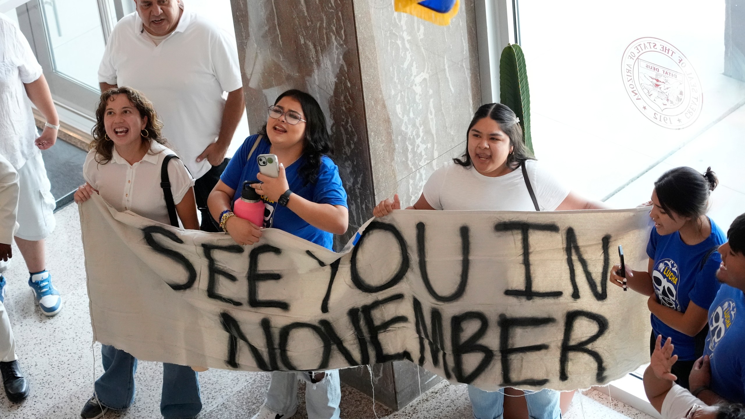 FILE Opponents to an immigration proposal gather inside the Arizona State Capitol, Tuesday, June 4, 2024, in Phoenix. Immigrant advocacy groups this week appealed a judge's ruling to allow the proposal to allow local law enforcement to arrest migrants who cross illegally from Mexico into Arizona between ports of entry to stay on the state's Nov. 5 ballot. (AP Photo/Matt York, File)