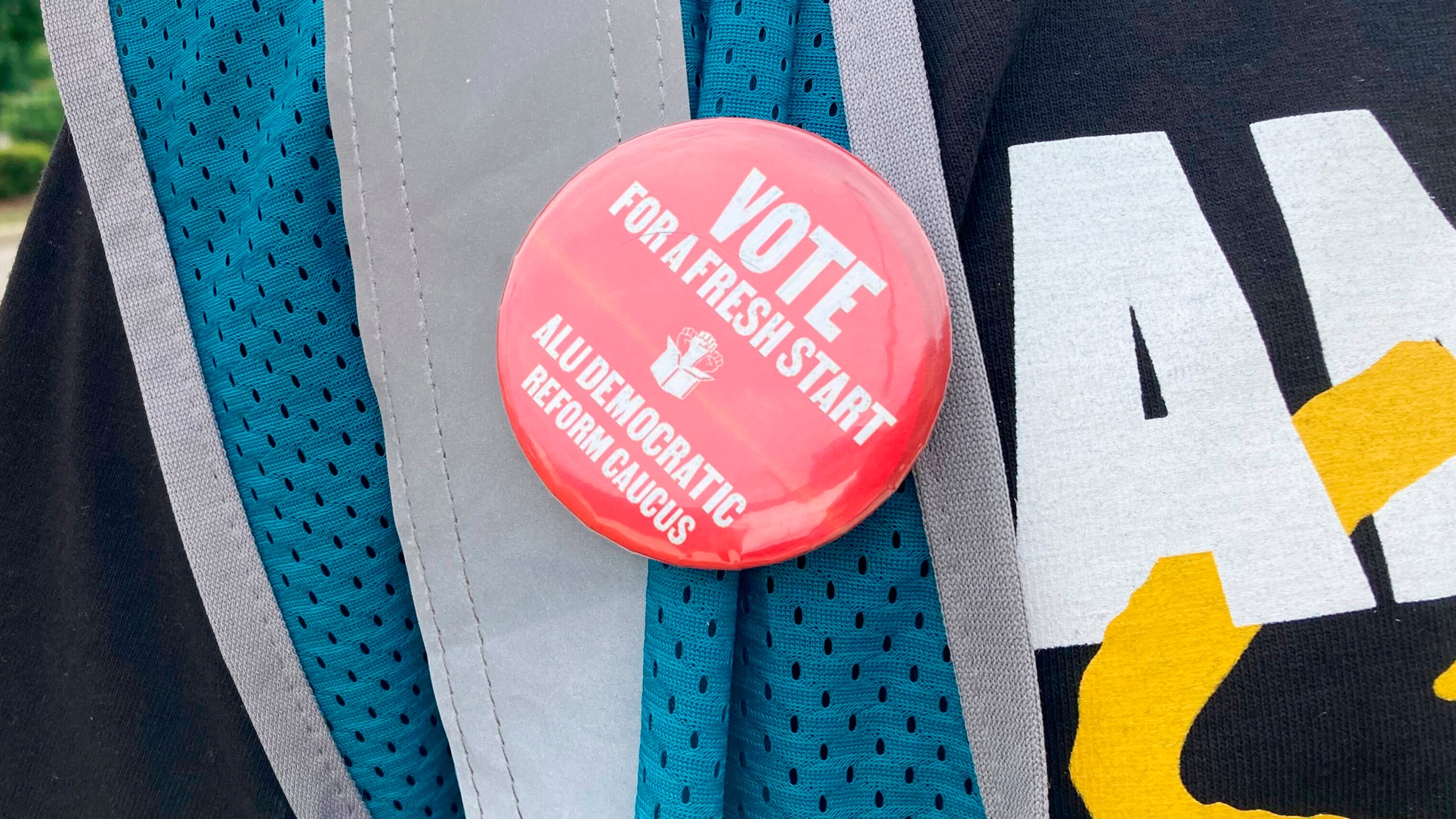 A pin hangs from a vest worn by union organizer and former Amazon worker Connor Spence outside the Amazon warehouse in the borough of Staten Island in New York in Tuesday, June 18, 2024. Workers at Amazon's only unionized warehouse in the U.S. elected new union leaders Tuesday, marking the first major change for the labor group since it established an alliance with the International Brotherhood of Teamsters. Spence is running to be president of the ALU-International Brotherhood of Teamsters Local 1. (AP Photo/Haleluya Hadero)