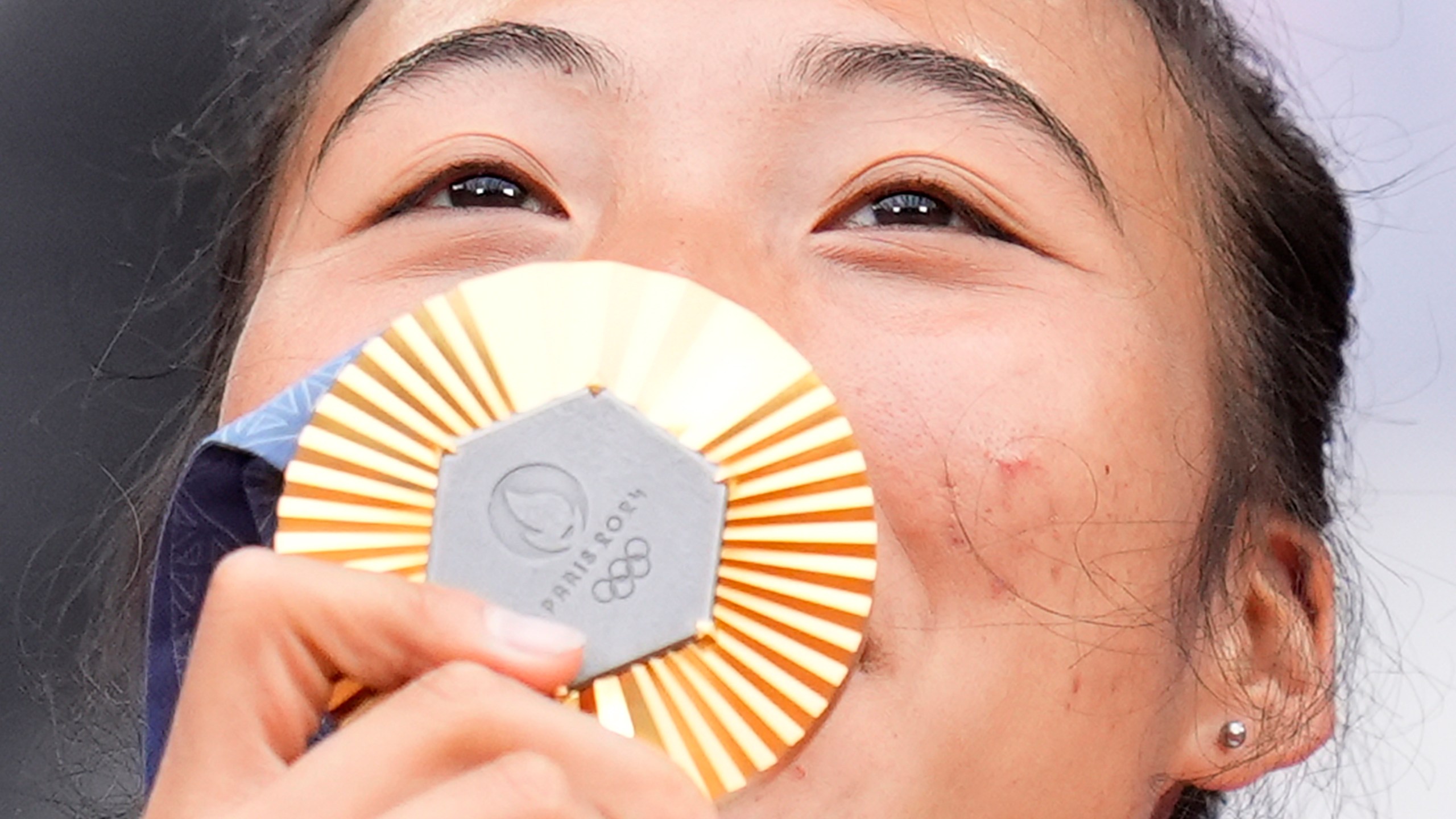 China's Zheng Qinwen kisses her gold medal after defeating Croatia's Donna Vekic during the Women's Singles tennis final at the Roland Garros stadium at the 2024 Summer Olympics, Saturday, Aug. 3, 2024, in Paris, France. (AP Photo/Manu Fernandez)