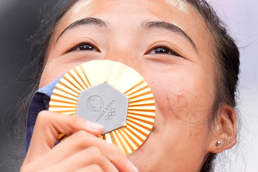 China's Zheng Qinwen kisses her gold medal after defeating Croatia's Donna Vekic during the Women's Singles tennis final at the Roland Garros stadium at the 2024 Summer Olympics, Saturday, Aug. 3, 2024, in Paris, France. (AP Photo/Manu Fernandez)