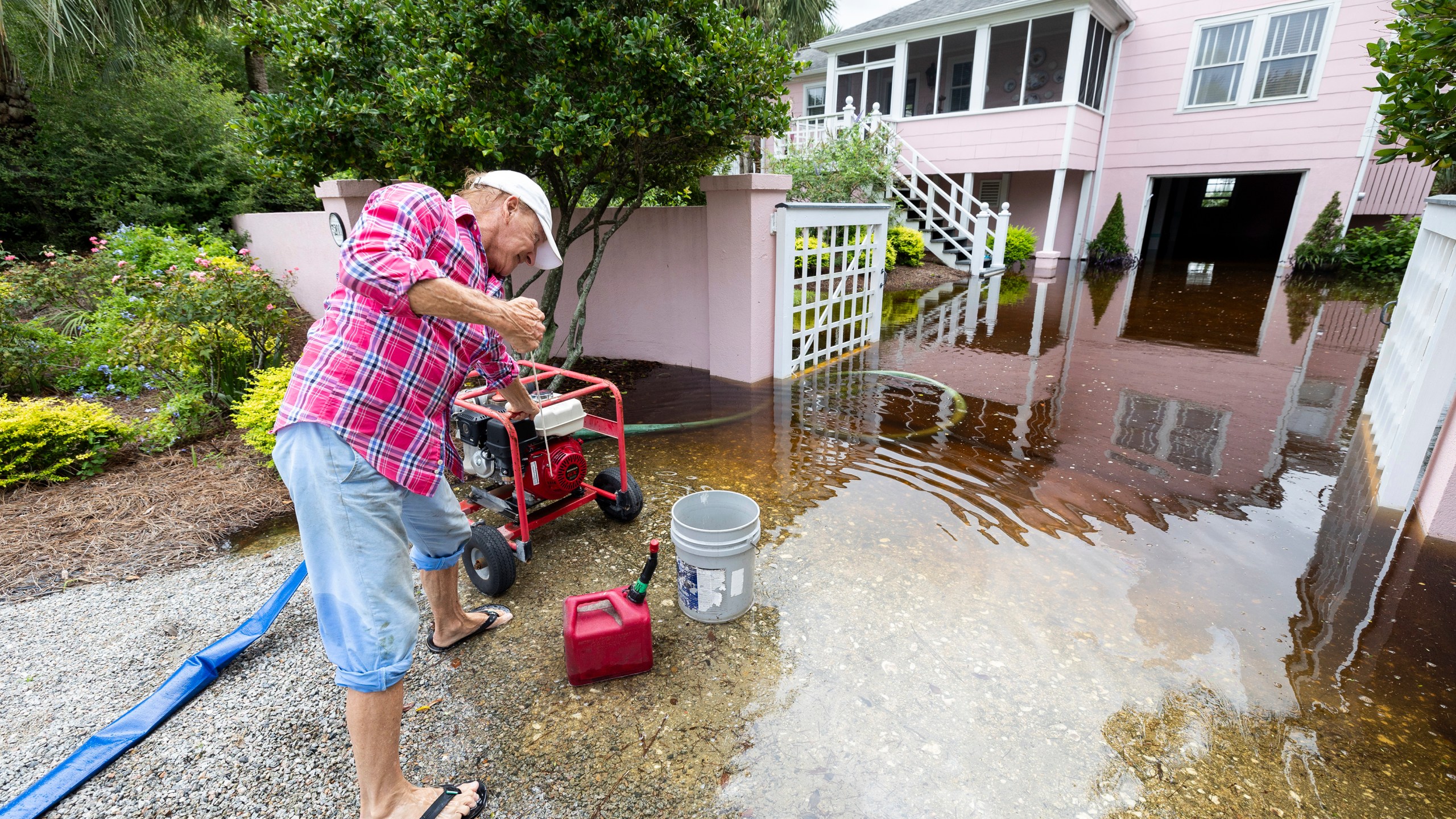 Robert Chesnut starts his water pump at his Palm Blvd. home after it was flooded by Tropical Storm Debby Thursday, Aug. 8, 2024, in Isle of Palms, S.C. (AP Photo/Mic Smith)