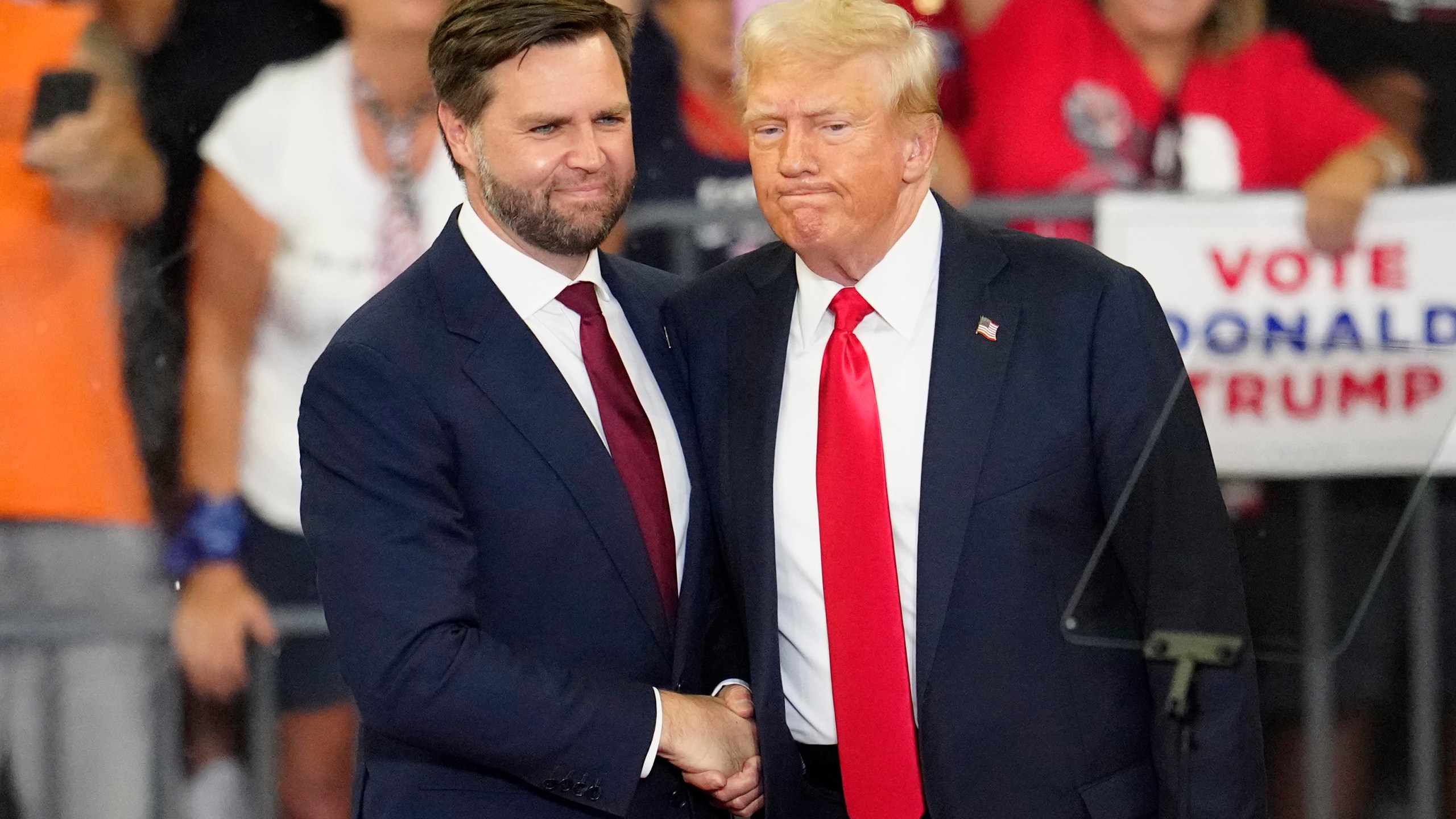 Republican vice presidential candidate Sen. JD Vance, R-Ohio, left, and Republican presidential candidate former President Donald Trump, shake hands at a campaign rally at Georgia State University in Atlanta, Saturday, Aug. 3, 2024. (AP Photo/Ben Gray)