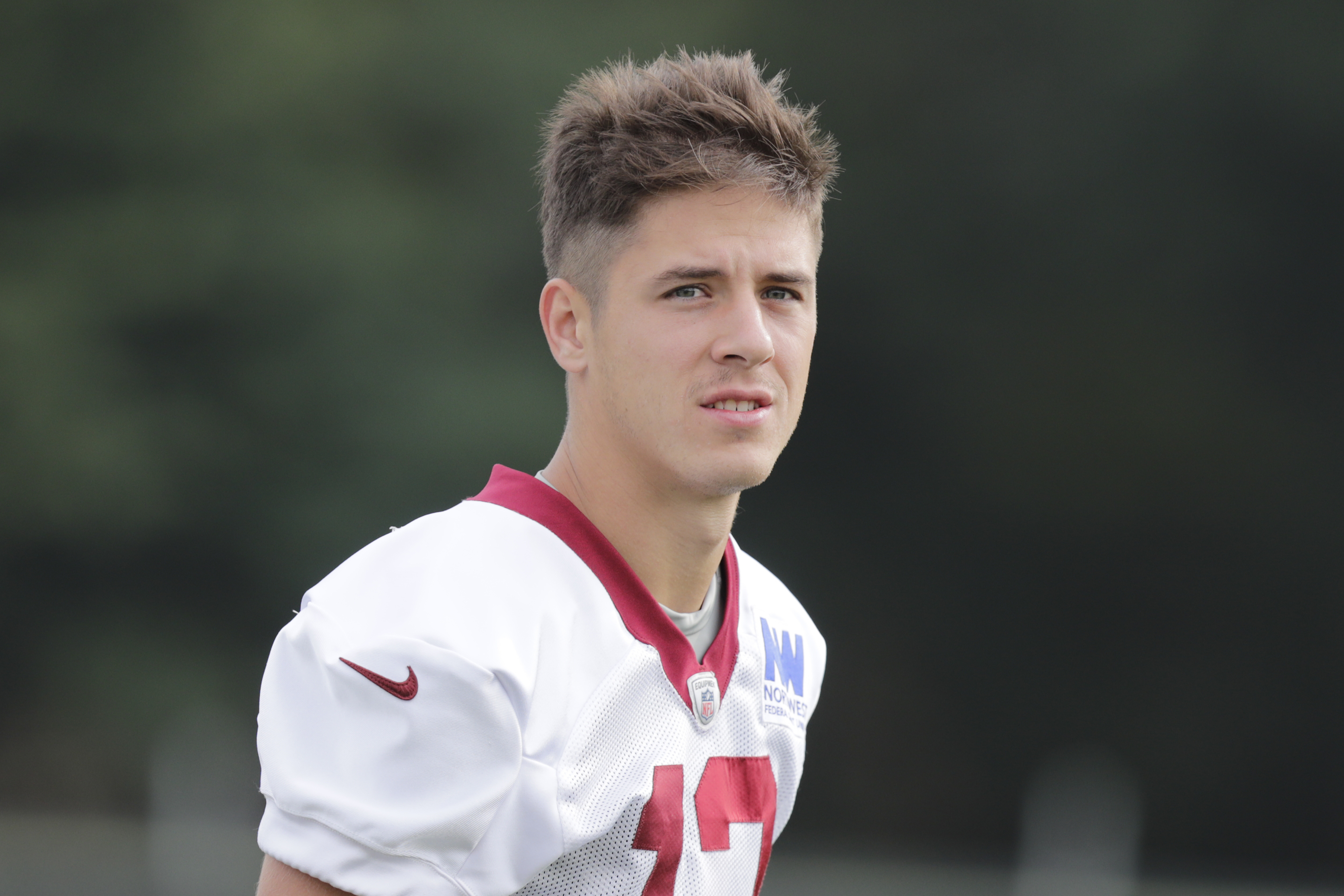 FILE - Washington Commanders wide receiver Luke McCaffrey walks onto the field during an NFL football practice at the team's training facility in Ashburn, Va., on July 26, 2024. Luke McCaffrey this weekend will become the latest member of his family to play in the NFL. (AP Photo/Luis M. Alvarez, File)