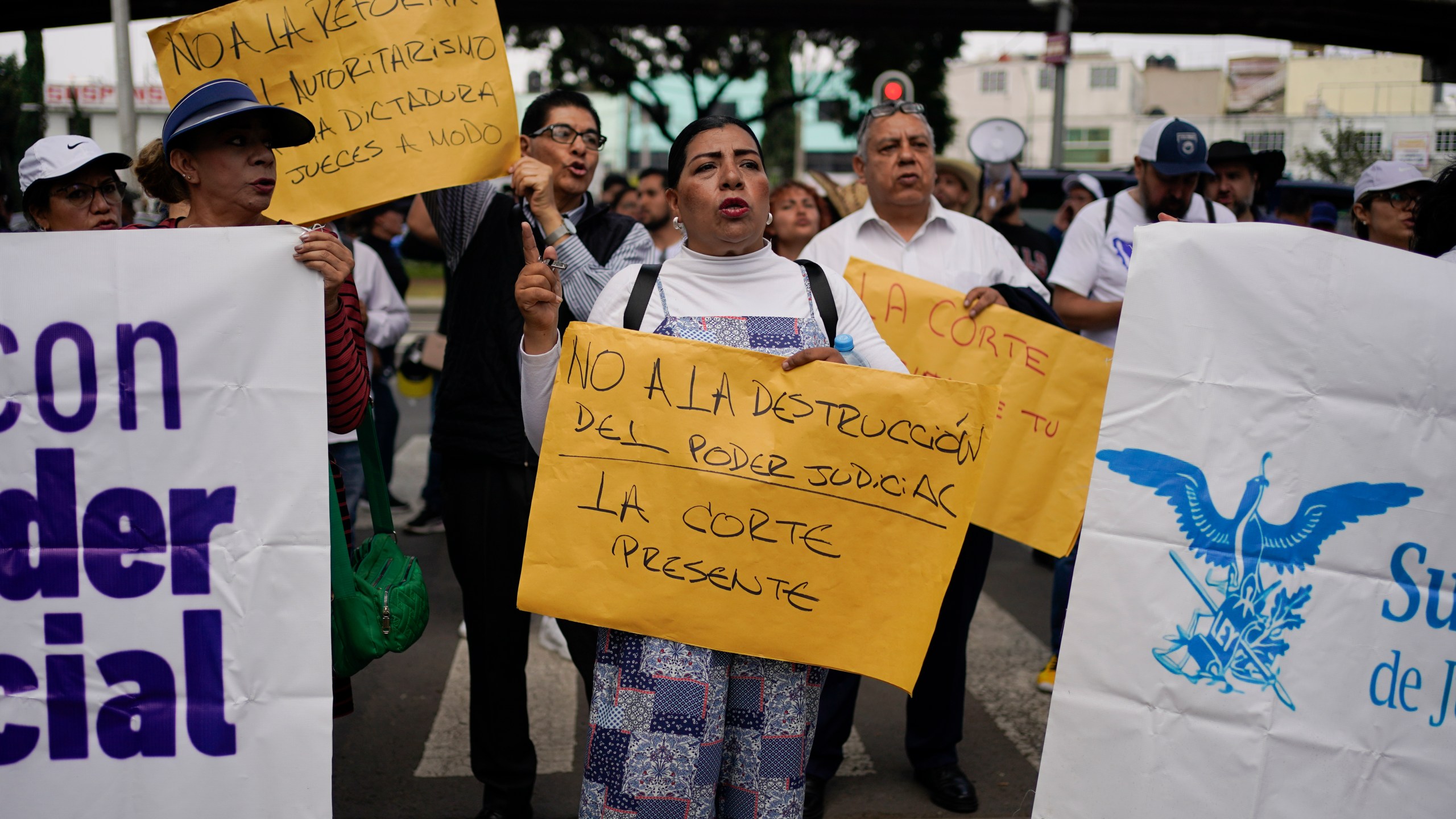 Judicial worker Norma Contreras protests constitutional reform proposals that would make judges stand for election, outside a sports center where lawmakers are meeting as an alternative due to other demonstrators blocking the Congress building in Mexico City, Tuesday, Sept. 3, 2024. Her sign reads in Spanish "No to the destruction of judicial power. The court is present." (AP Photo/Felix Marquez)