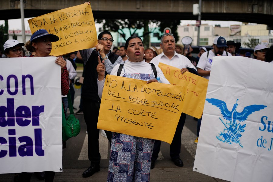 Judicial worker Norma Contreras protests constitutional reform proposals that would make judges stand for election, outside a sports center where lawmakers are meeting as an alternative due to other demonstrators blocking the Congress building in Mexico City, Tuesday, Sept. 3, 2024. Her sign reads in Spanish "No to the destruction of judicial power. The court is present." (AP Photo/Felix Marquez)