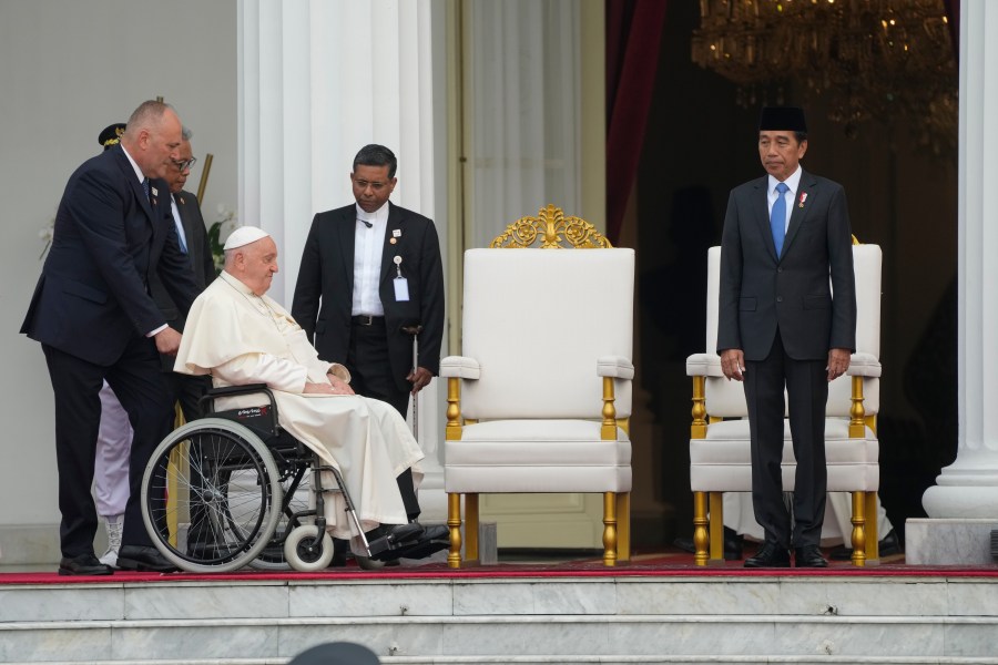 Indonesian President Joko Widodo, right, receives Pope Francis, helped on a wheelchair by assistant Piergiorgio Zanetti, at Istana Merdeka Presidential Palace in Jakarta, Wednesday, Sept. 4, 2024. Pope Francis is opening his visit to Indonesia with a packed first day Wednesday, meeting political and religious leaders and setting a rigorous pace for an 11-day, four-nation trip through tropical Asia and Oceania that will test his stamina and health. (AP Photo/Gregorio Borgia)