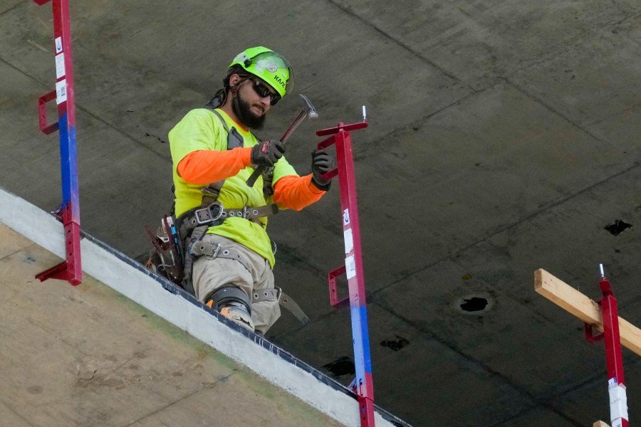 A construction worker installs a safety railing on a new building in Philadelphia, Tuesday, Sept. 3, 2024. (AP Photo/Matt Rourke)