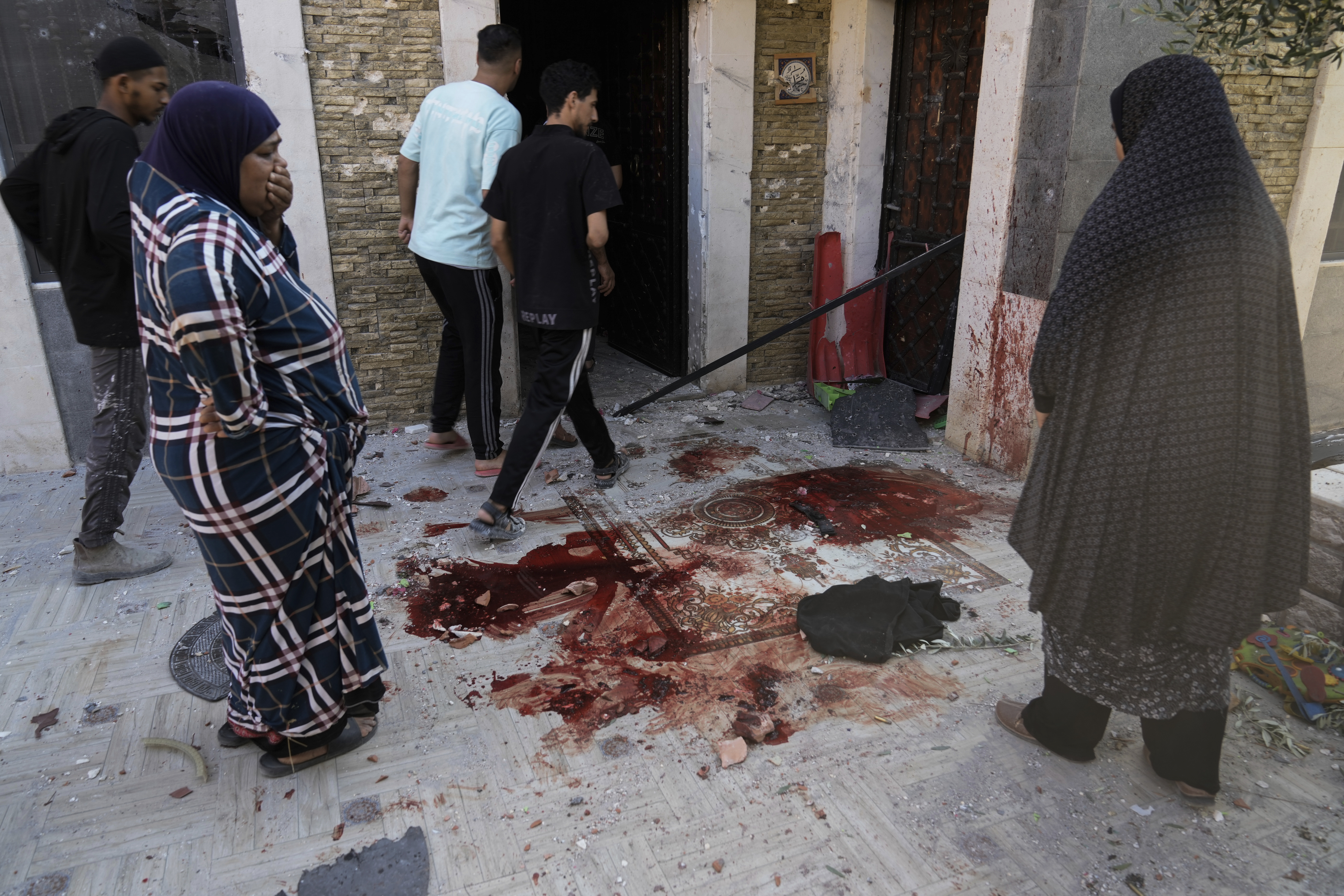 Palestinians look at blood stains at the site of an Israeli army raid where Palestinians say two were killed near Tulkarem, West Bank, Tuesday, Sept. 3, 2024. The dead were not immediately identified, but Israel launched a major offensive in the area last week in an operation it says is aimed against Palestinian militants. (AP Photo/Majdi Mohammed)