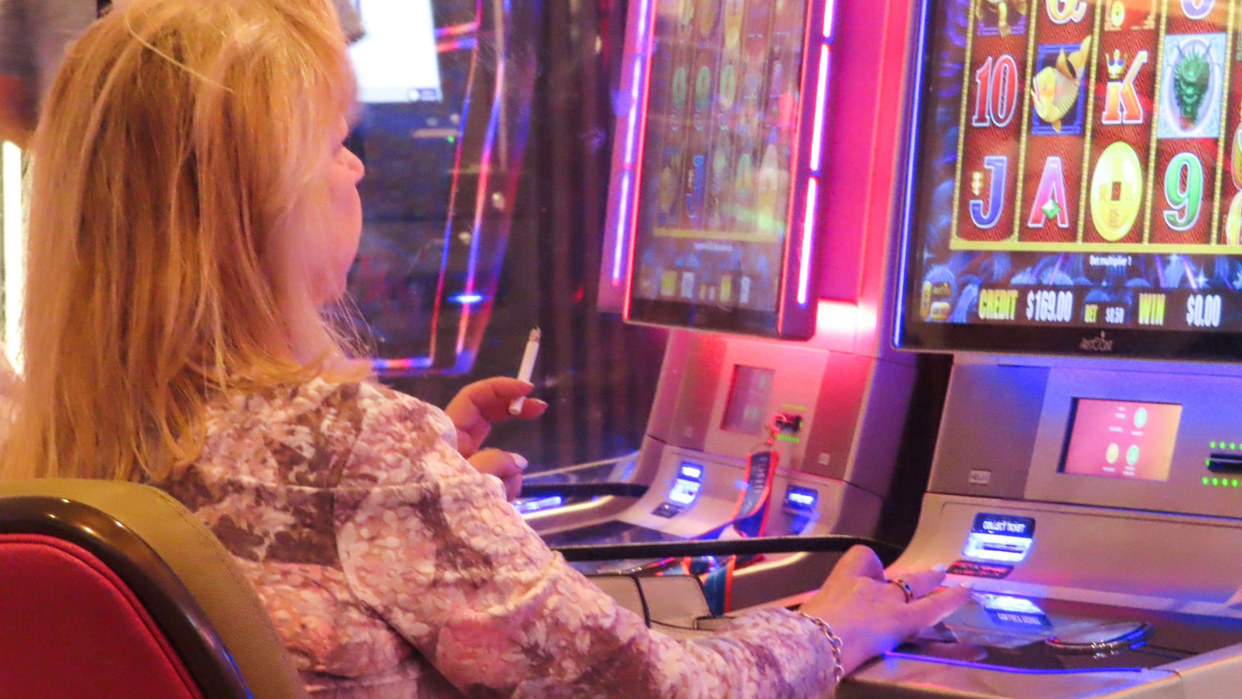 A gambler smokes while playing a slot machine at the Hard Rock casino in Atlantic City, N.J., on Aug. 8, 2022. (AP Photo/Wayne Parry)