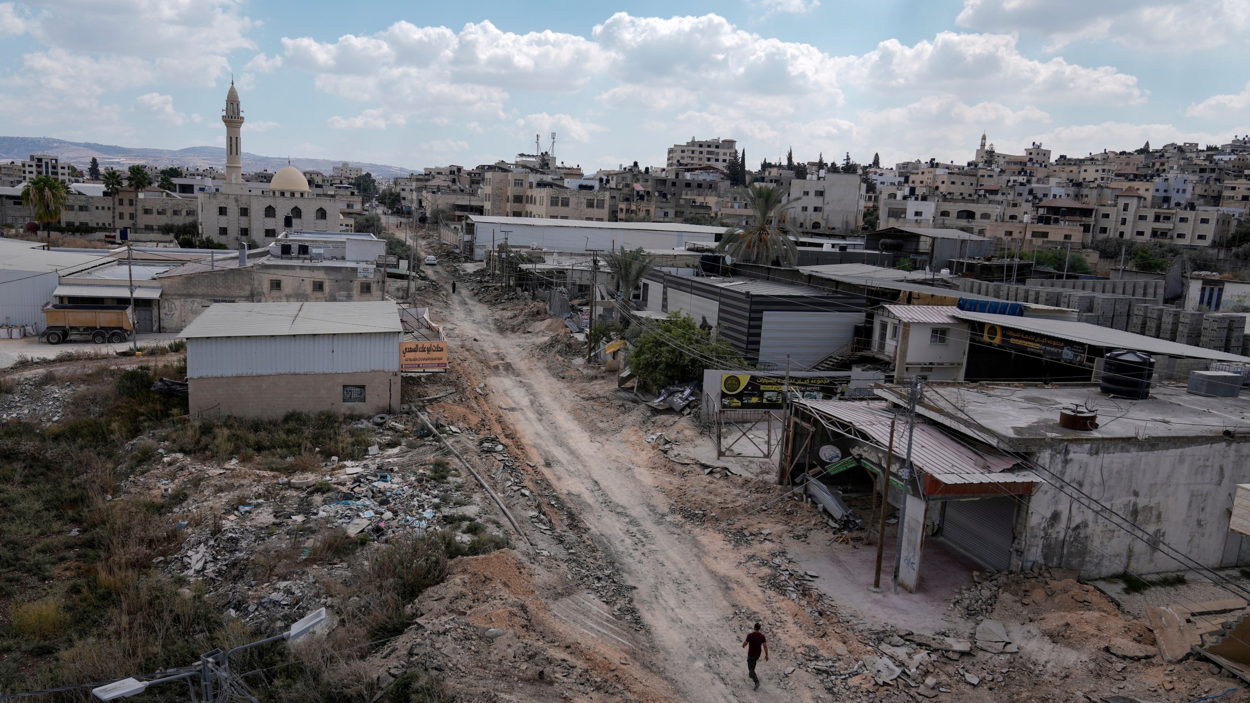 A man walks on a damaged road following an Israeli army raid in Jenin, West Bank, on Wednesday, Sept. 4, 2024. (AP Photo/Majdi Mohammed)