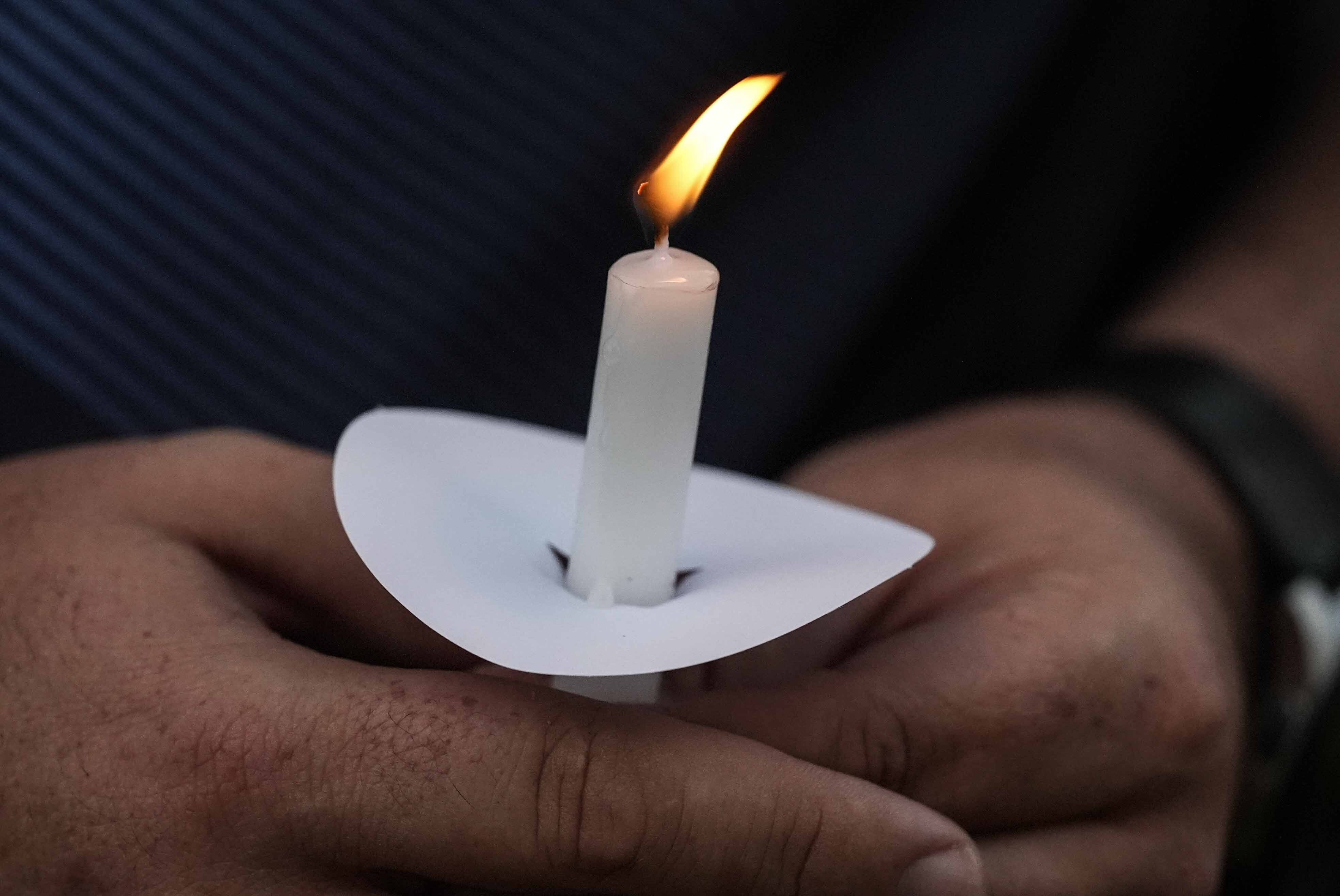 Mark Gorman holds a candle during a candlelight vigil for the slain students and teachers at Apalachee High School, Wednesday, Sept. 4, 2024, in Winder, Ga. (AP Photo/Mike Stewart)