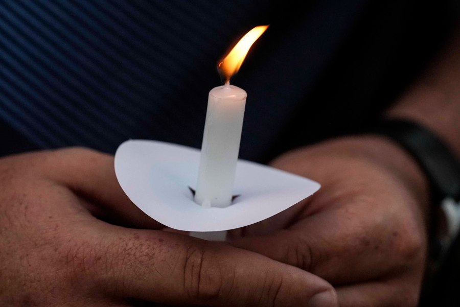 Mark Gorman holds a candle during a candlelight vigil for the slain students and teachers at Apalachee High School, Wednesday, Sept. 4, 2024, in Winder, Ga. (AP Photo/Mike Stewart)