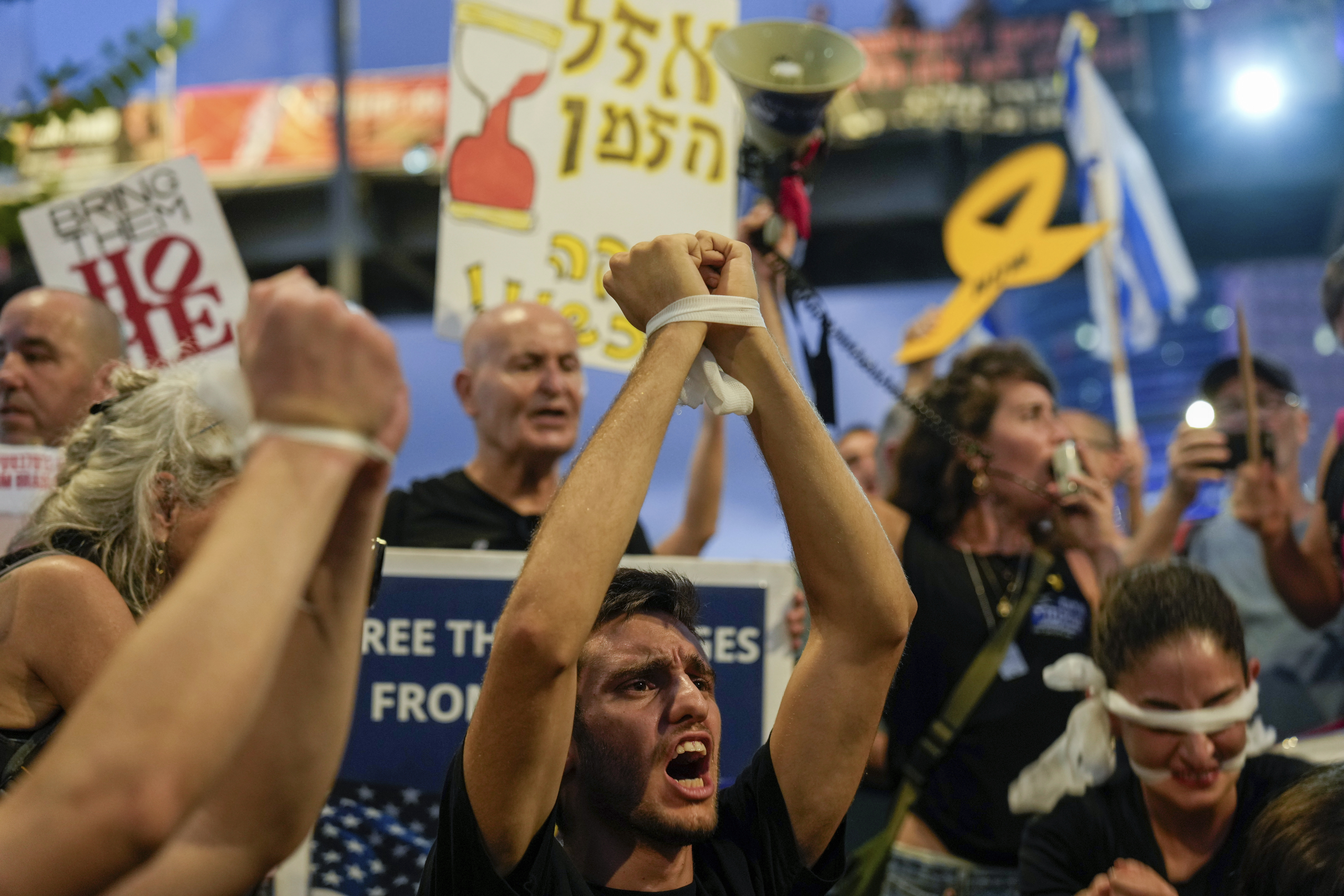 A demonstrator with his hands tied calls for a cease-fire deal and the immediate release of hostages held in Gaza during a protest in Tel Aviv, Israel on Wednesday, Sept. 4, 2024. (AP Photo/Ariel Schalit)