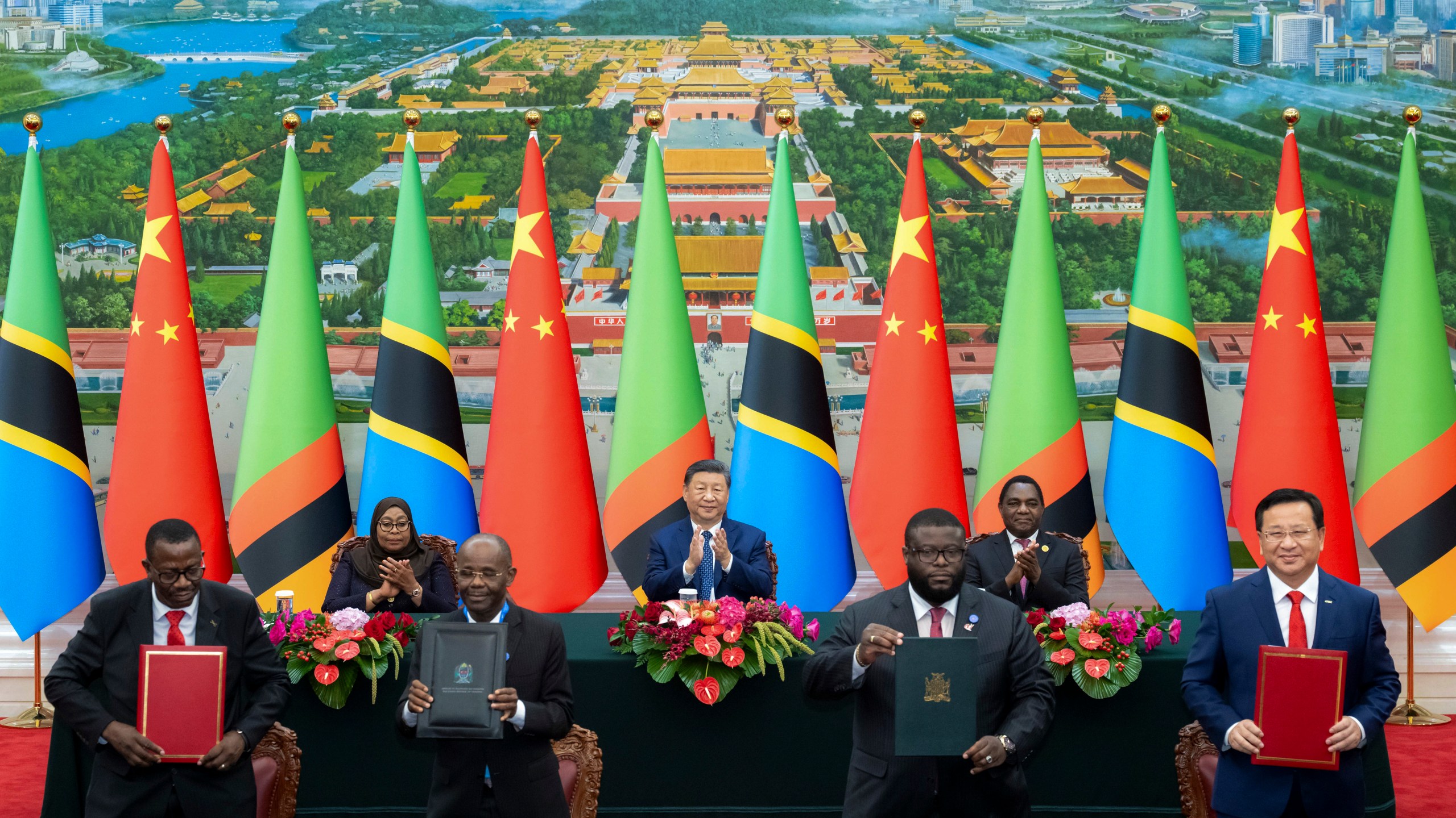 In this photo released by Xinhua News Agency, real from left, Tanzania's President Samia Suluhu Hassan, Chinese President Xi Jinping and Zambia President Hakainde Hichilema applaud as they witness the signing of a memorandum of understanding on the revitalisation project of the Tanzania-Zambia Authority railway, at the Great Hall of the People in Beijing, Wednesday, Sept. 4, 2024, ahead of the China Africa Forum. (Zhai Jianlan/Xinhua via AP)