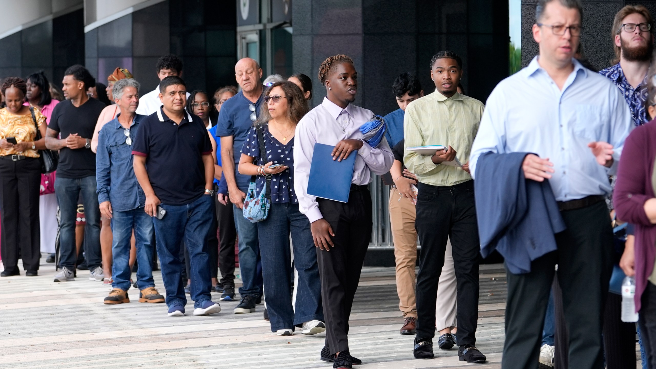 People wait in line to attend a job fair, Thursday, Aug. 29, 2024, in Sunrise, Fla. (AP Photo/Lynne Sladky)