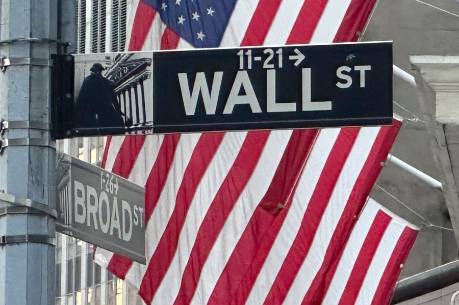 FILE - Signs at the intersection of Broad and Wall Streets stand near flags flying from the New York Stock Exchange on Sept. 4, 2024, in New York. (AP Photo/Peter Morgan, File)