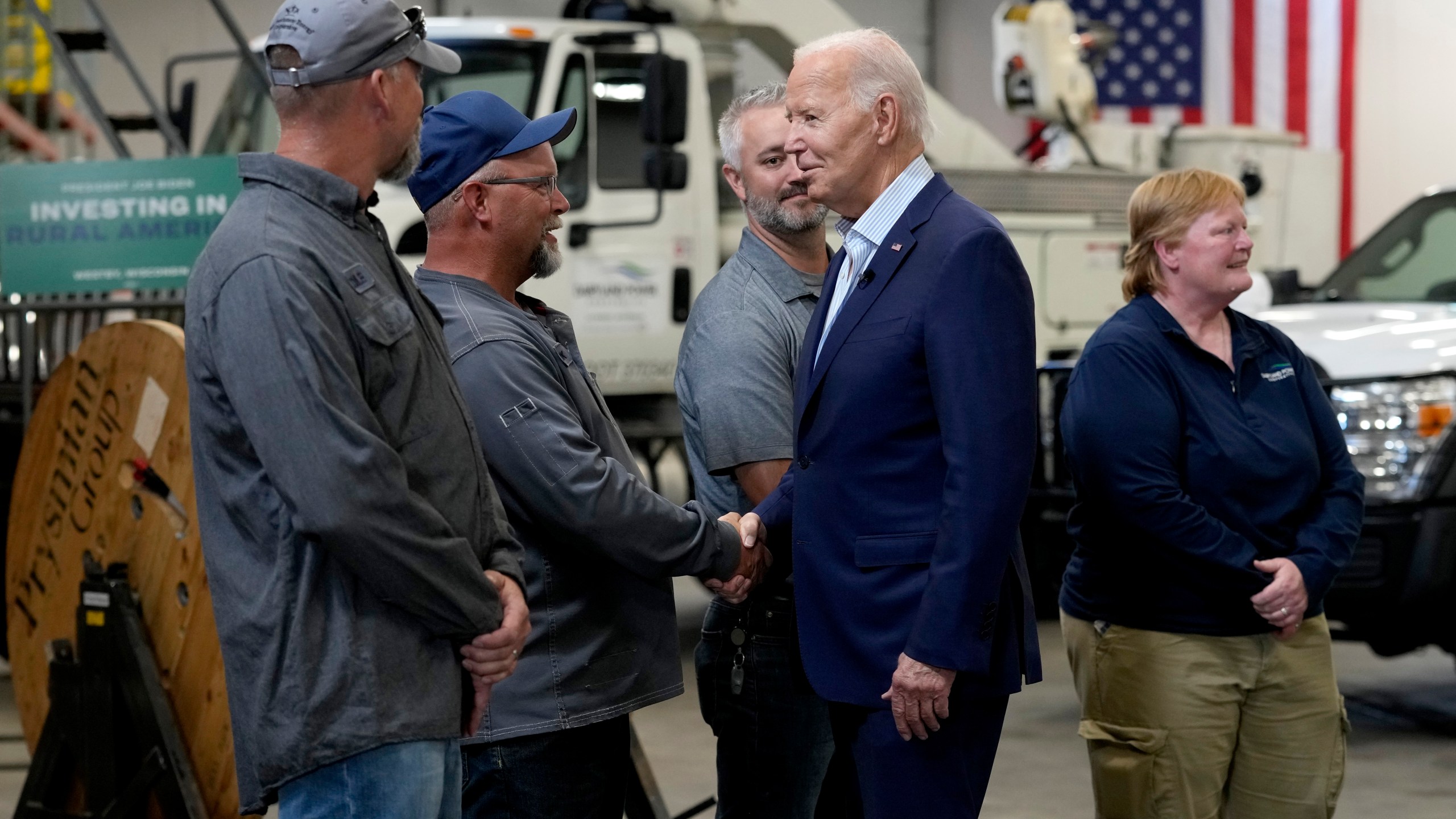 President Joe Biden, second from right, greets workers from Dairyland Power Cooperative and Vernon Electric Cooperative during a visit to Vernon Electric in Westby, Wis., Thursday, Sept. 5, 2024. Biden is in Wisconsin to promote his Investing in America agenda. (AP Photo/Susan Walsh)