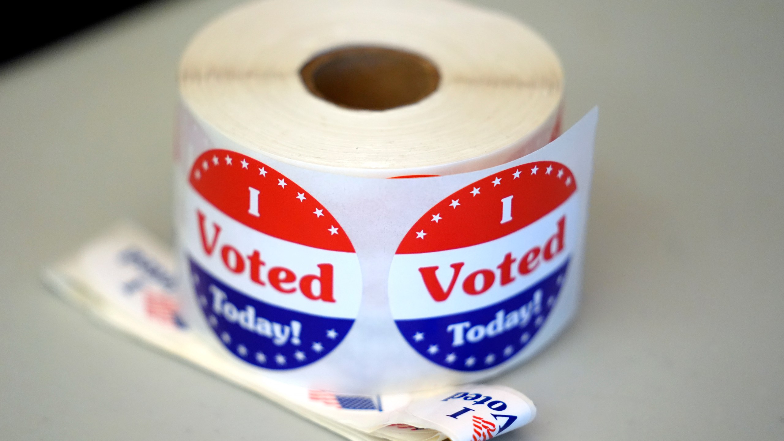 FILE - A spool of stickers rests on a table at a polling station during Massachusetts state primary voting, Sept. 3, 2024, in Newton, Mass. (AP Photo/Steven Senne, File)