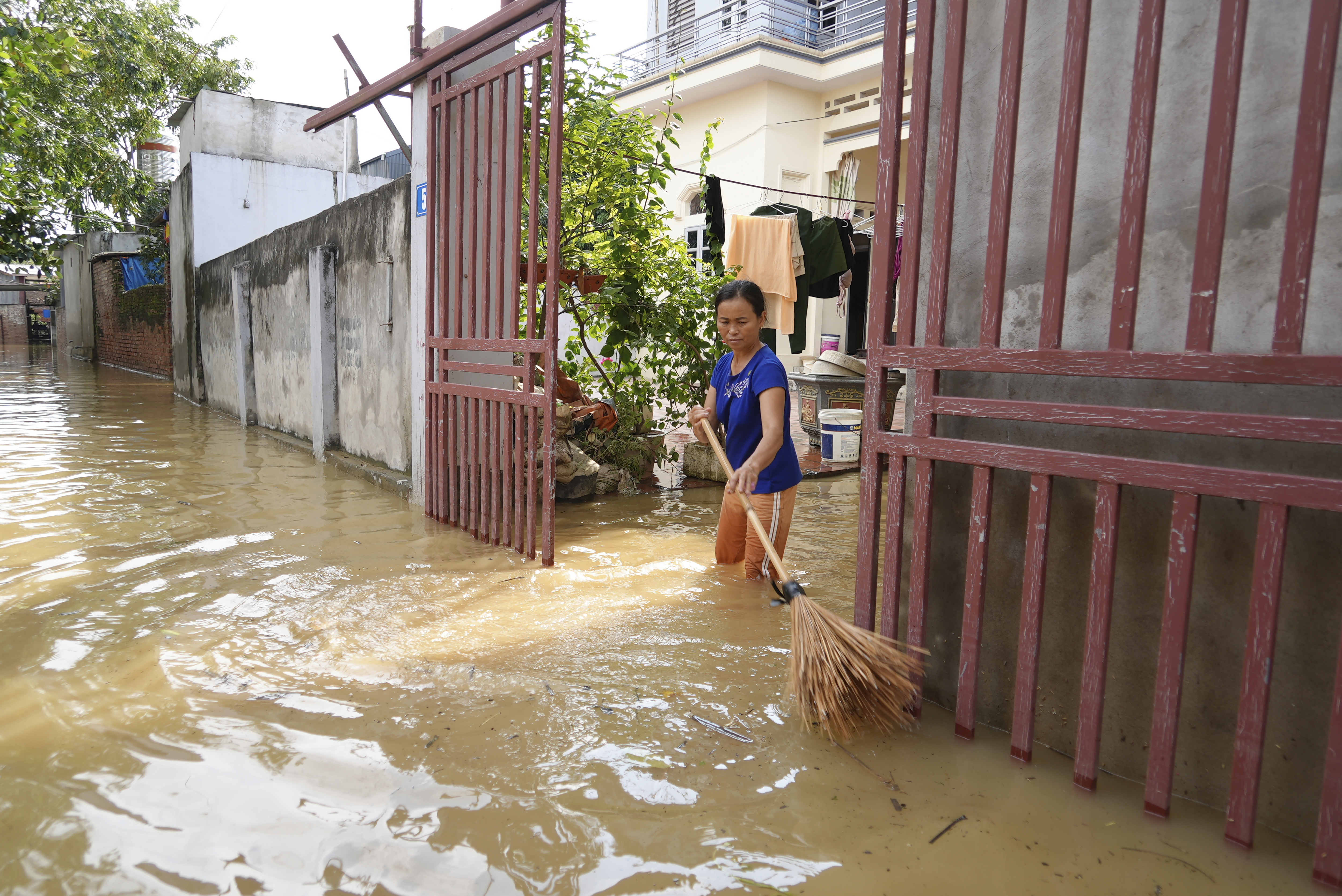 A woman cleans her house as flood recedes in the aftermath of Typhoon Yagi in An Lac village, Hanoi, Vietnam Friday, Sept. 13, 2024. (AP Photo/Hau Dinh)