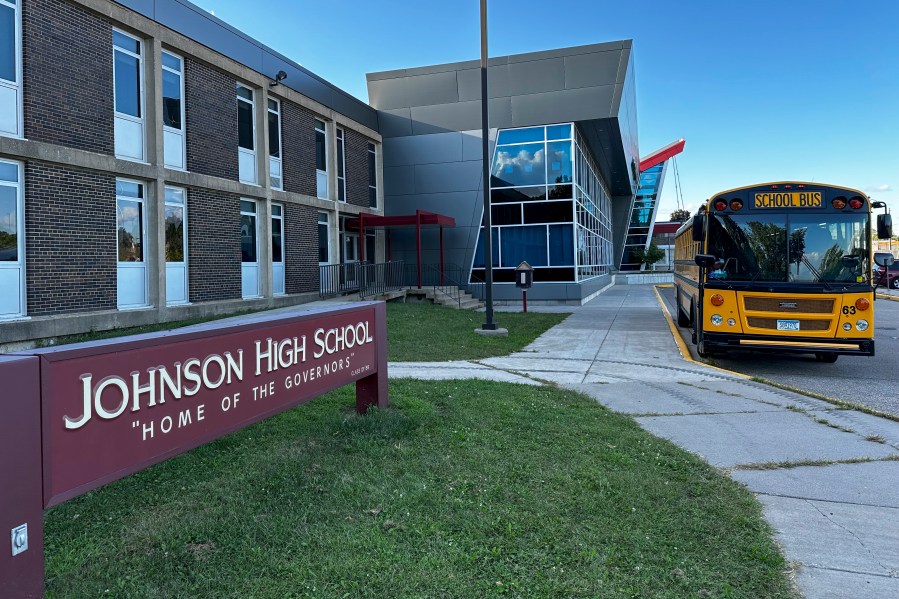 A school bus sits outside Johnson Senior High School in St. Paul, Minn., Sept. 5, 2024. (AP Photo/Doug Glass)