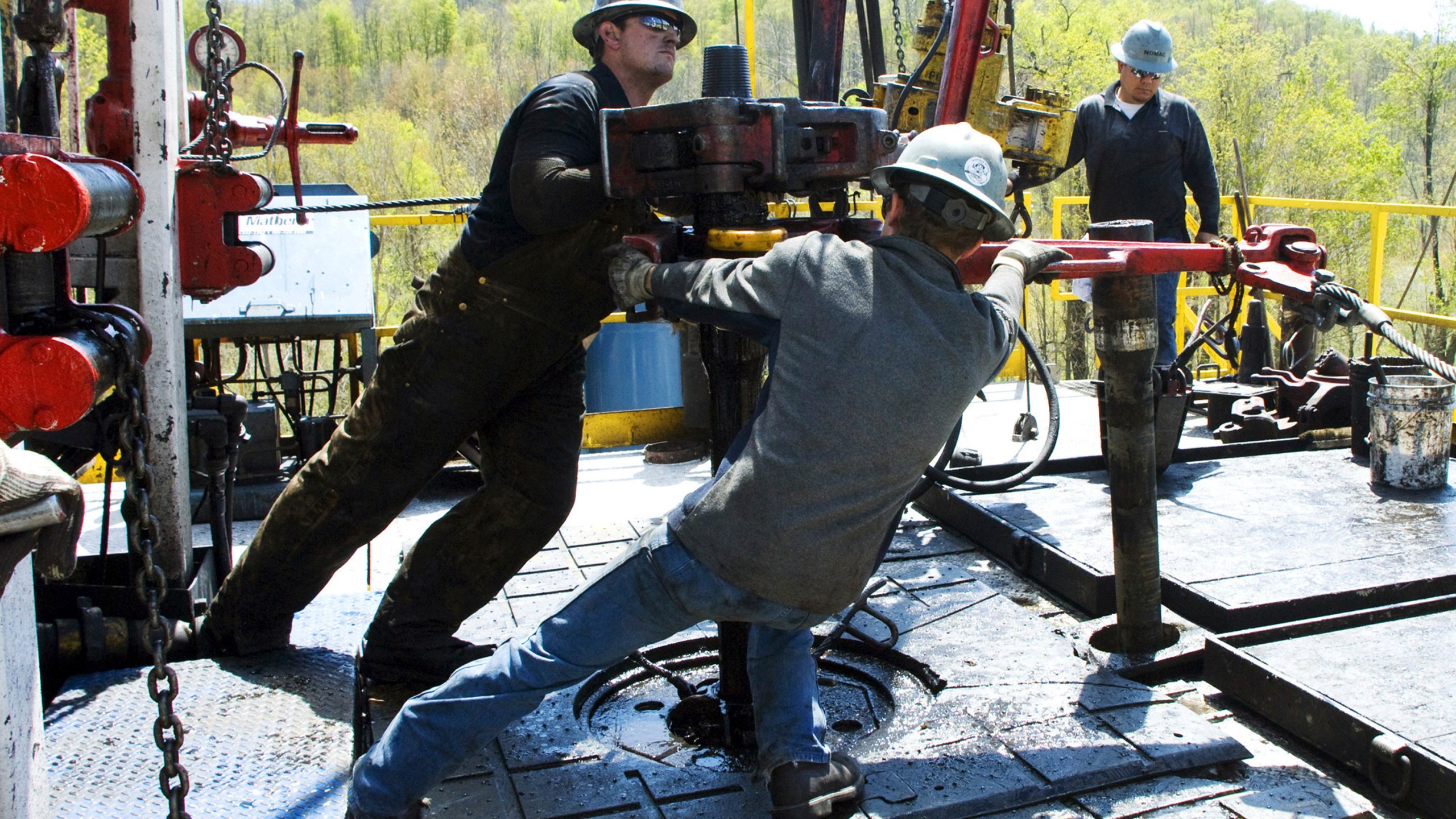 FILE - Workers move a section of well casing into place at a Chesapeake Energy natural gas well site near Burlington, Pa., in Bradford County, on April 23, 2010. (AP Photo/Ralph Wilson, File)