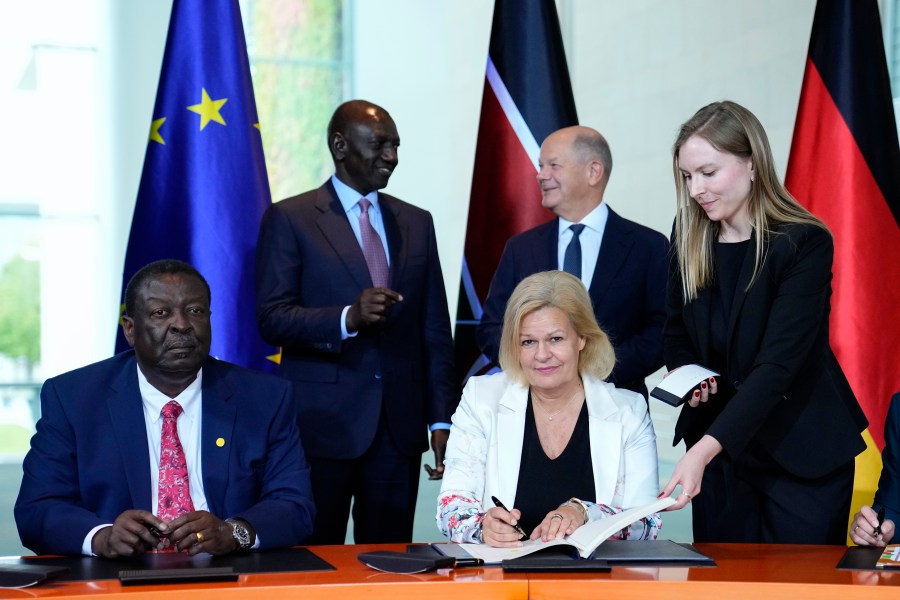 German Interior Minister Nancy Faeser, down right, signs a migration agreement with Kenyan's Prime Cabinet Secretary Musalia Mudavadi, left, as German Chancellor Olaf Scholz, centre behind, and Kenyan President William Ruto, left behind, at the chancellery in Berlin, Friday, Sept. 13, 2024. (AP Photo/Ebrahim Noroozi)