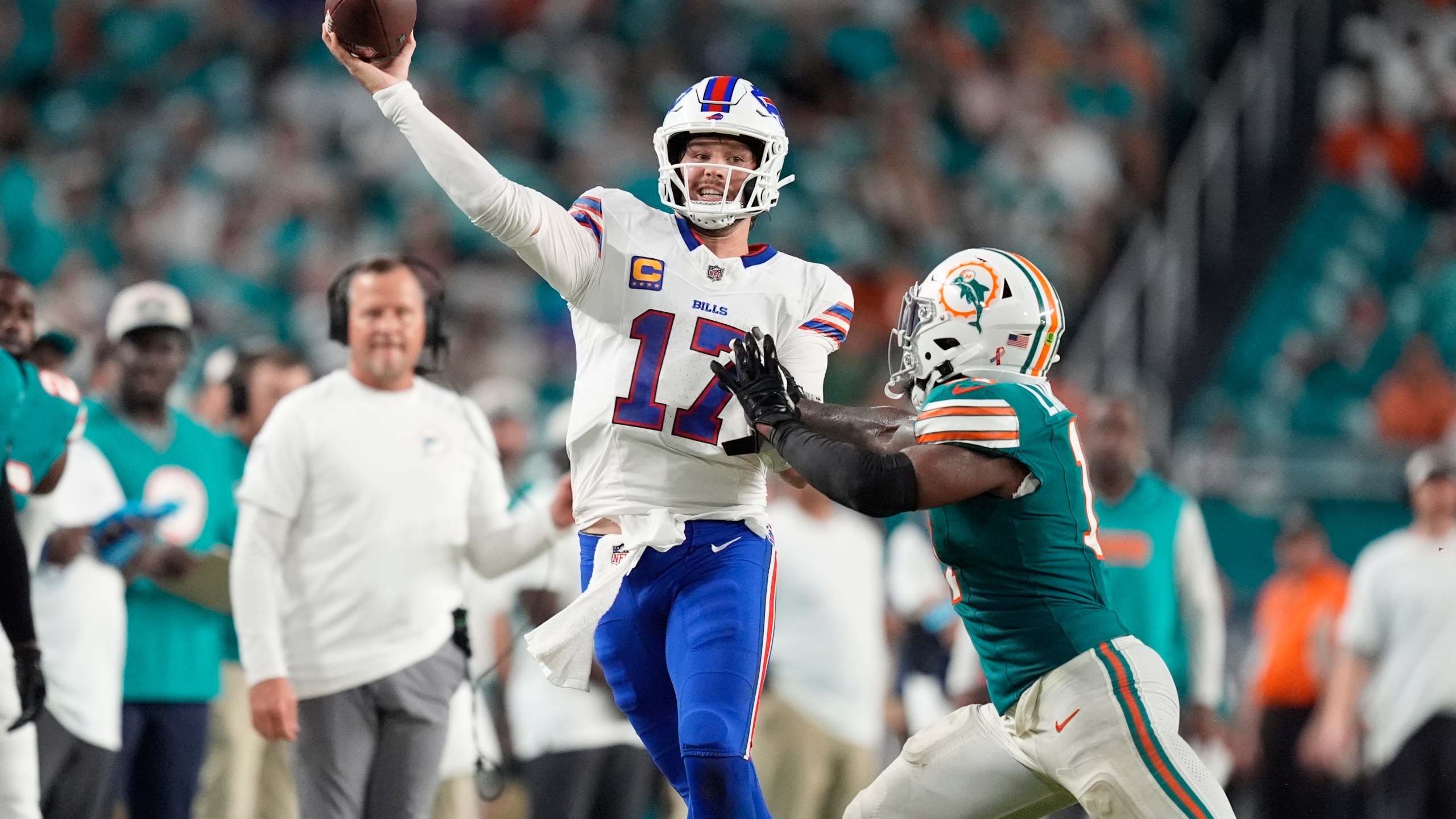 Buffalo Bills quarterback Josh Allen (17) aims a pass under pressure from Miami Dolphins linebacker David Long Jr. during the second half of an NFL football game, Thursday, Sept. 12, 2024, in Miami Gardens, Fla. (AP Photo/Rebecca Blackwell)