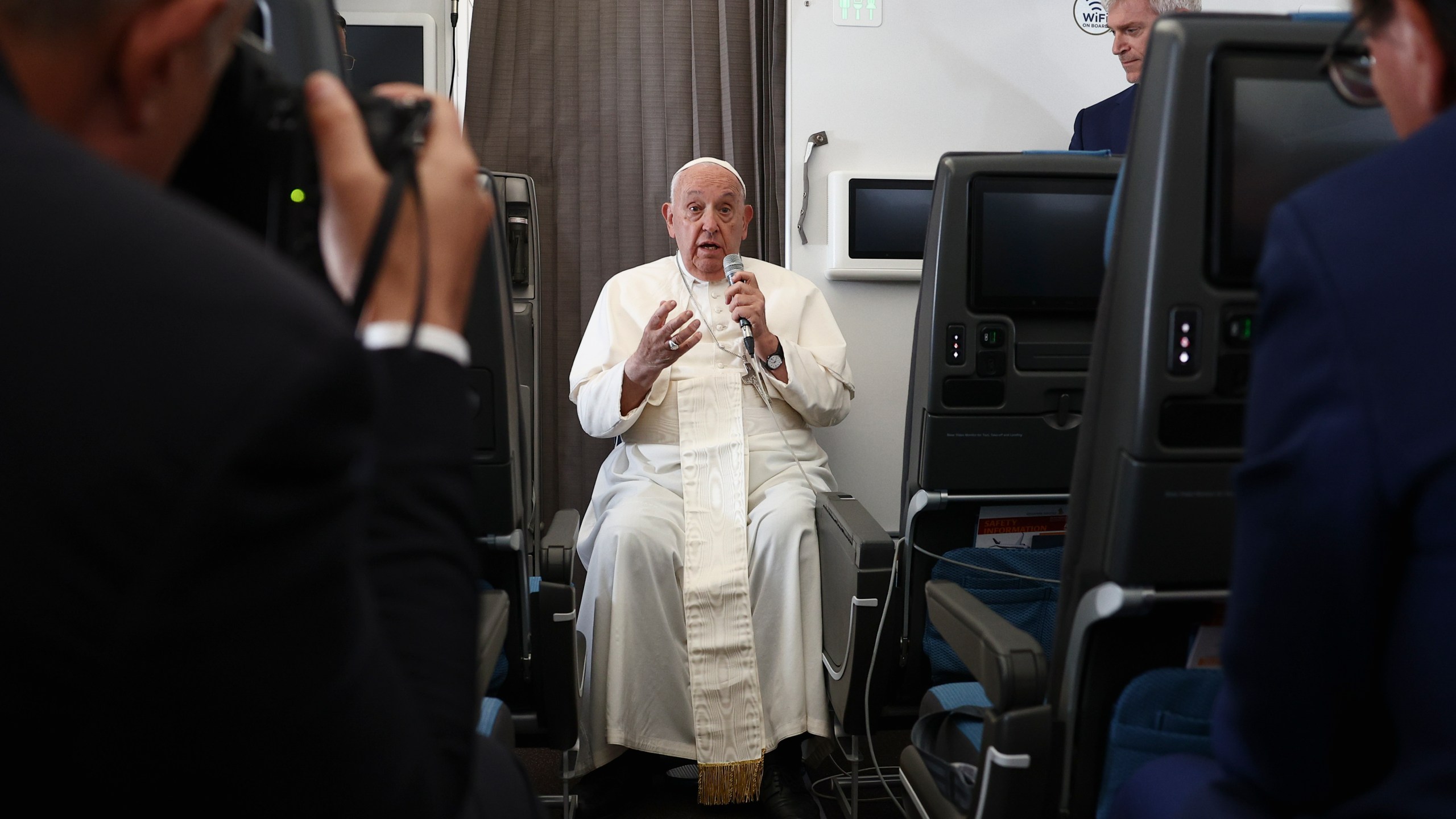 Pope Francis holds a news conference aboard the papal plane on his flight back after his 12-day journey across Southeast Asia and Oceania, Friday, Sept. 13, 2024. (Guglielmo Mangiapane/Pool Photo via AP)