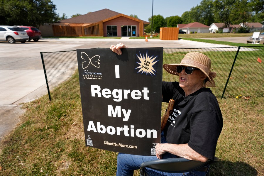 Anti-abortion protester Deborah Green-Myers, from Pittsburg, Kan., demonstrates outside a recently opened Planned Parenthood clinic, Tuesday, Sept. 10, 2024, in Pittsburg, Kan. (AP Photo/Charlie Riedel)