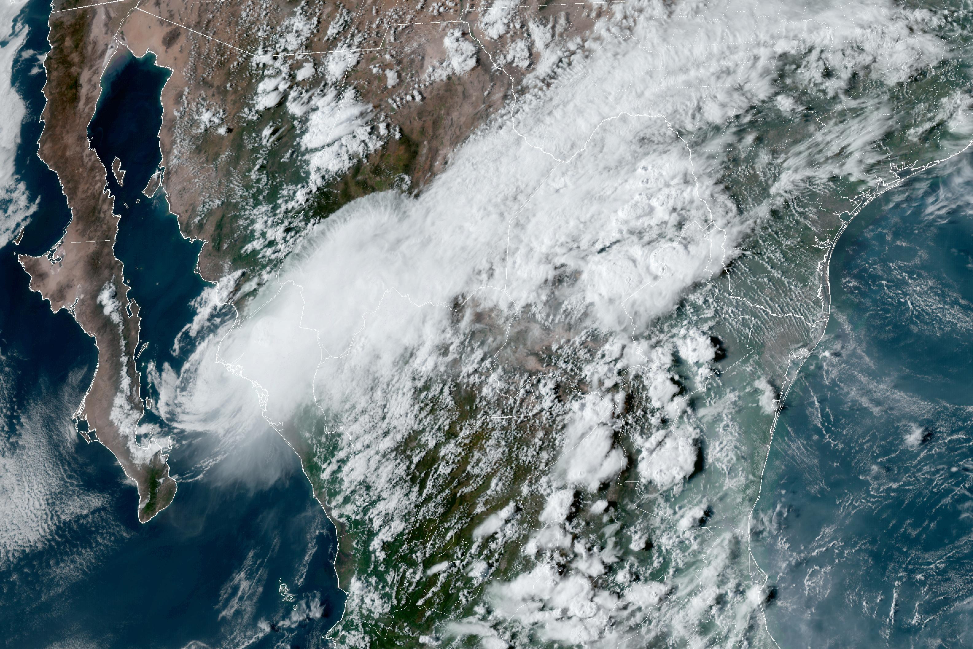 This satellite image provided by the U.S. National Oceanic and Atmospheric Administration shows Tropical Storm Ileana, left, near the coastal Mexican city of Topolobampo on the eastern side of the Gulf of California, on Saturday, Sept. 14, 2024, at 6:10 p.m. EDT. (NOAA via AP)