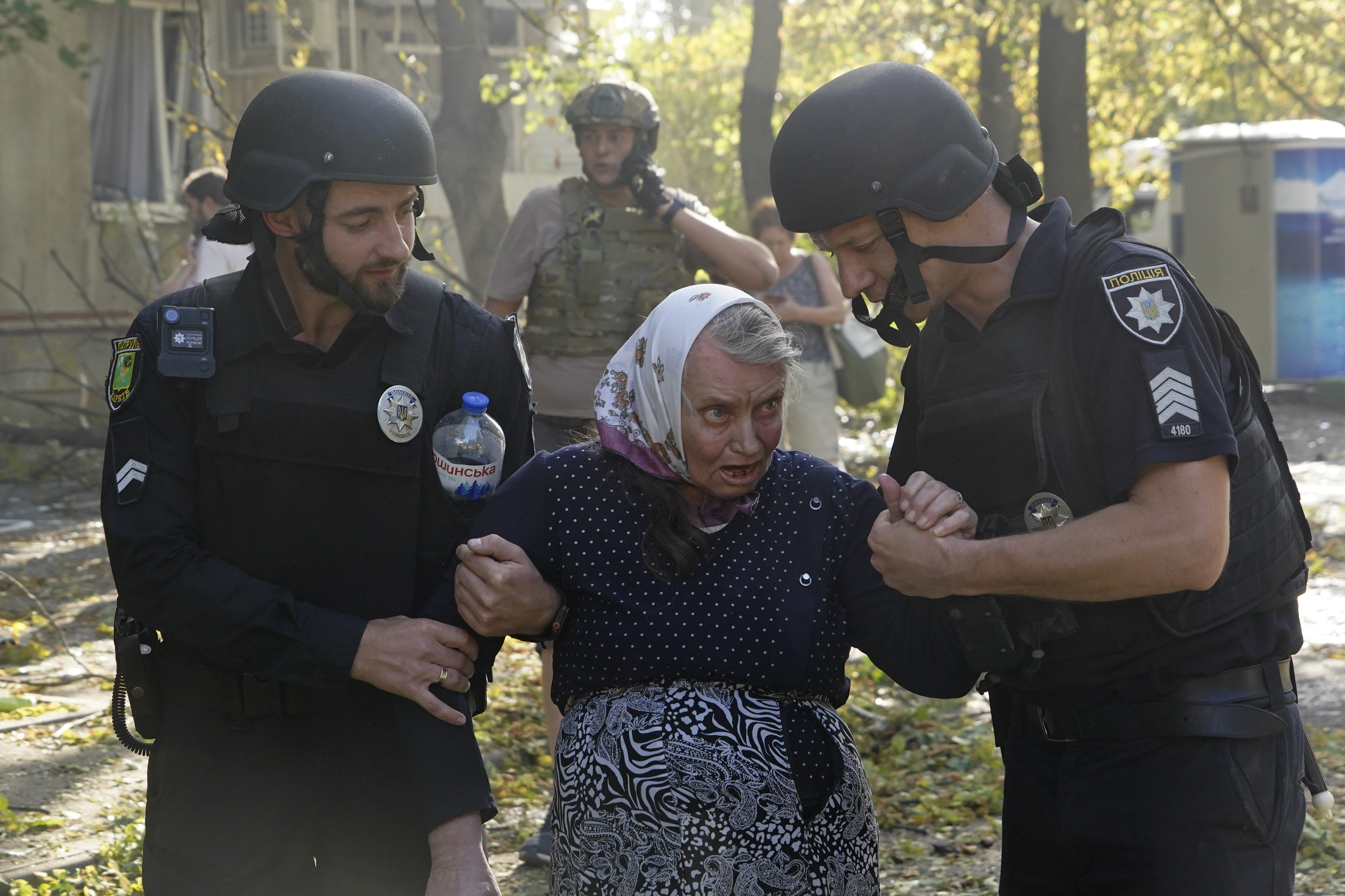 An elderly woman is assisted after a Russian aerial bomb struck a multi-story residential building in Kharkiv, Ukraine, Sunday Sept. 15, 2024. (AP Photo/Andrii Marienko)