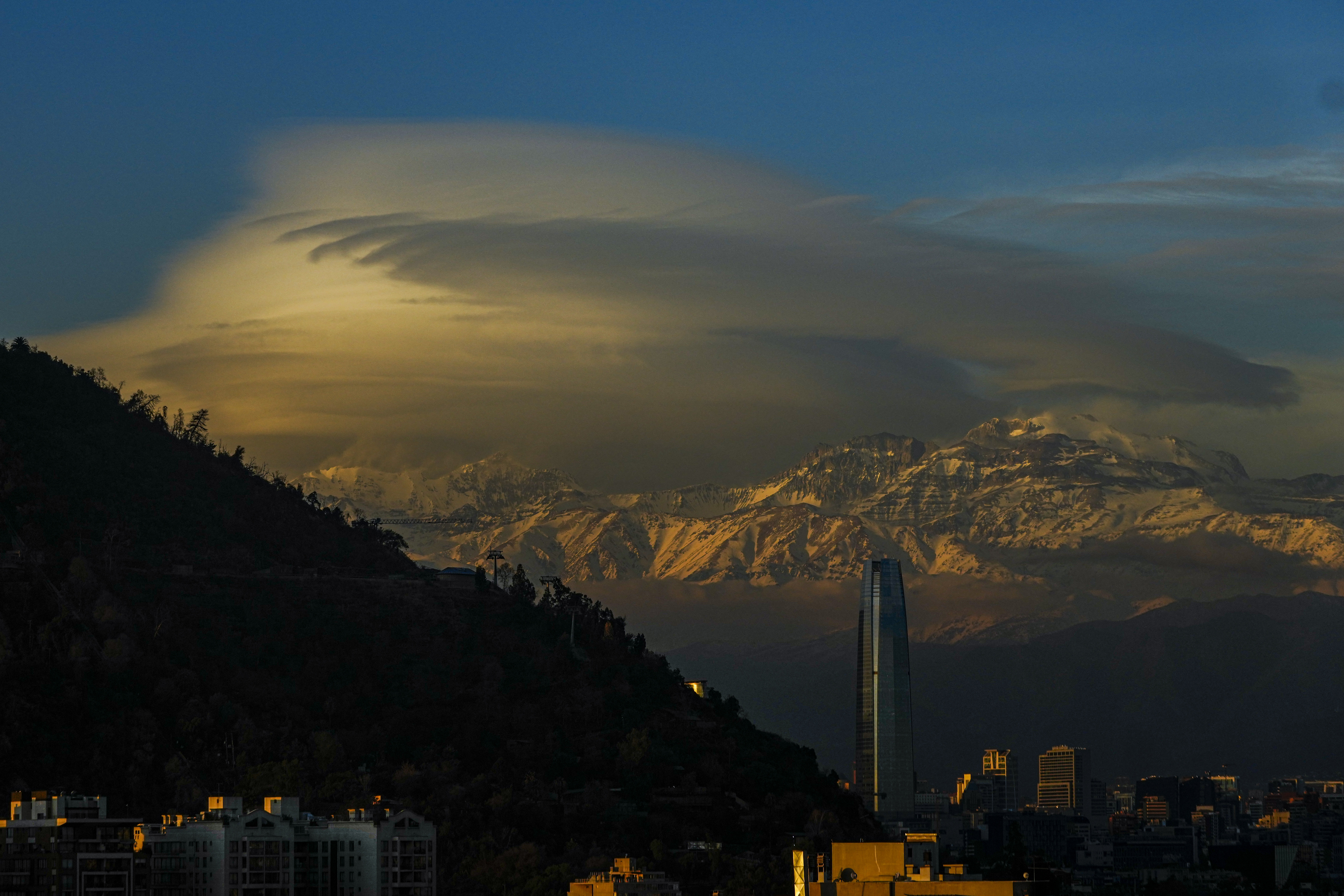 FILE - Clouds hover over the Andes Mountains in Santiago, Chile, June 19, 2024. (AP Photo/Esteban Felix, File)