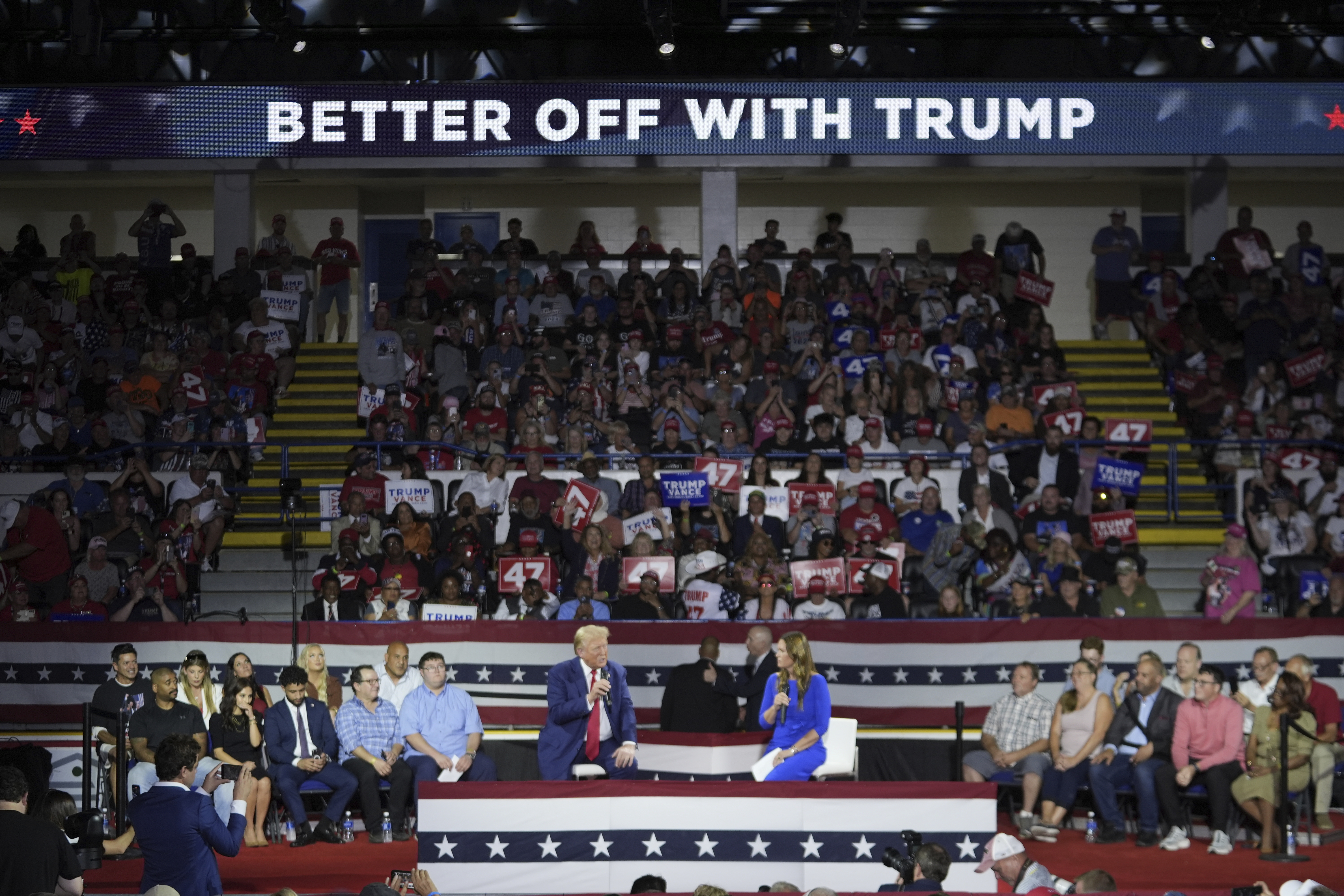 Republican presidential candidate former President Donald Trump, left, on stage with Arkansas Gov. Sarah Huckabee Sanders, right, during a town hall event at the Dort Financial Center, Tuesday, Sept. 17, 2024, in Flint, Mich. (AP Photo/Paul Sancya)