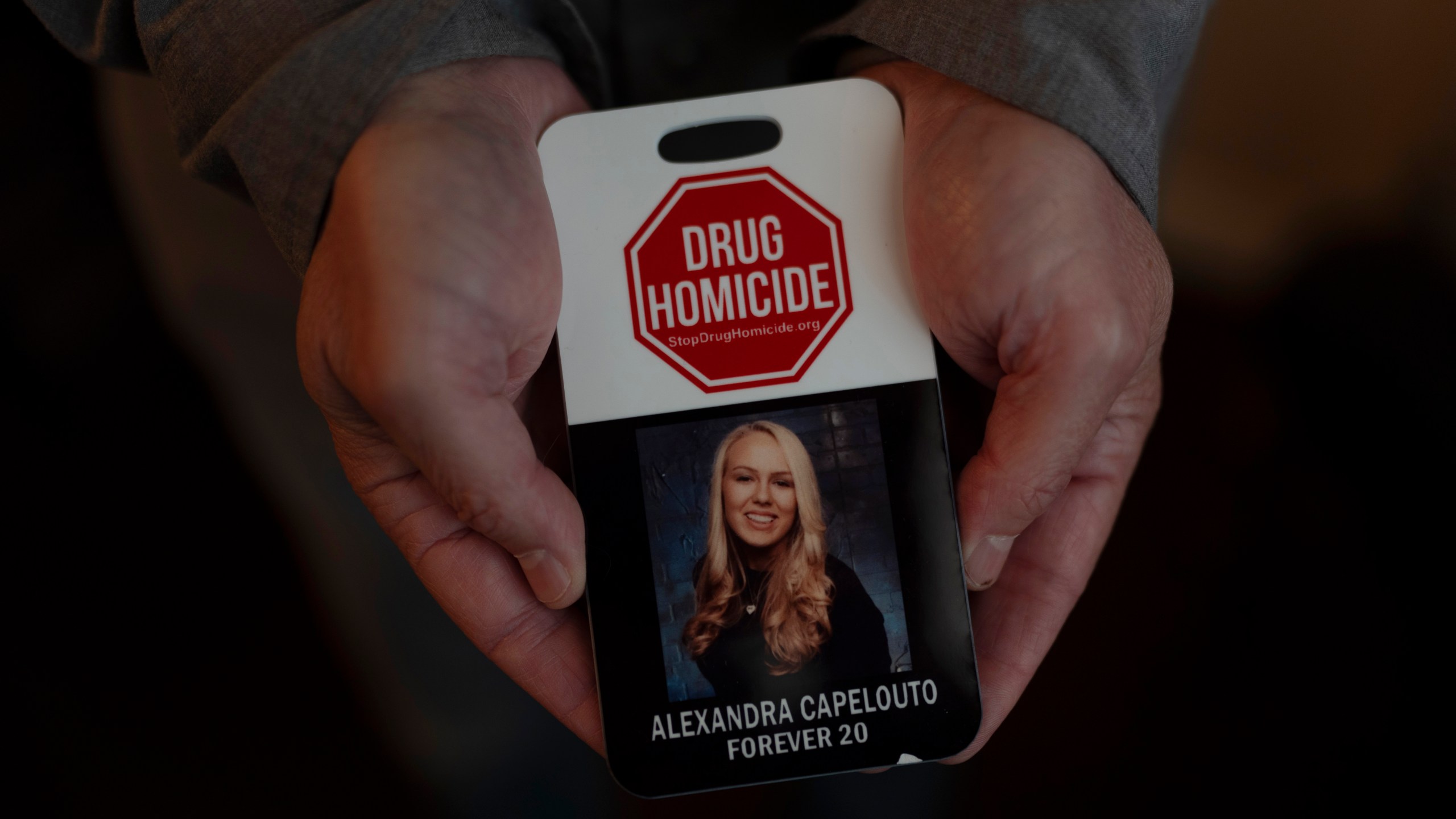 Matt Capelouto, whose daughter, Alexandra, died from a fentanyl overdose, holds an awareness card advocating for legal action against those responsible for drug-related deaths in Temecula, Calif., Tuesday, Sept. 17, 2024. (AP Photo/Jae C. Hong)