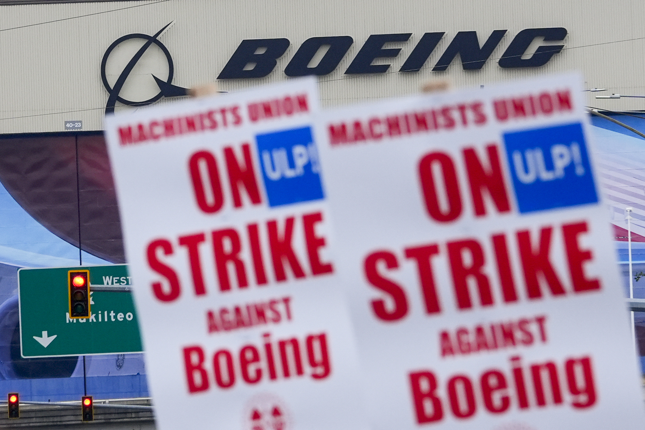 Boeing workers wave picket signs as they strike after union members voted to reject a contract offer, Sunday, Sept. 15, 2024, near the company's factory in Everett, Wash. (AP Photo/Lindsey Wasson)