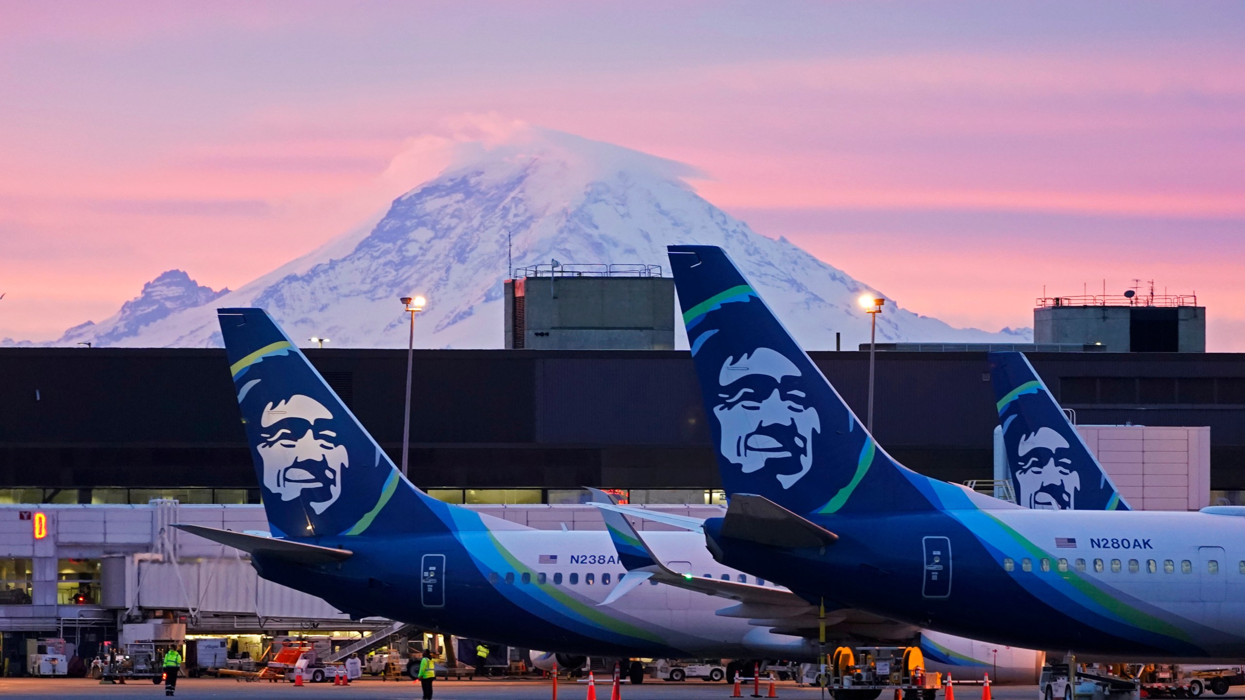 FILE - Alaska Airlines planes are shown parked at gates with Mount Rainier in the background on March 1, 2021, at Seattle-Tacoma International Airport in Seattle. (AP Photo/Ted S. Warren, File)