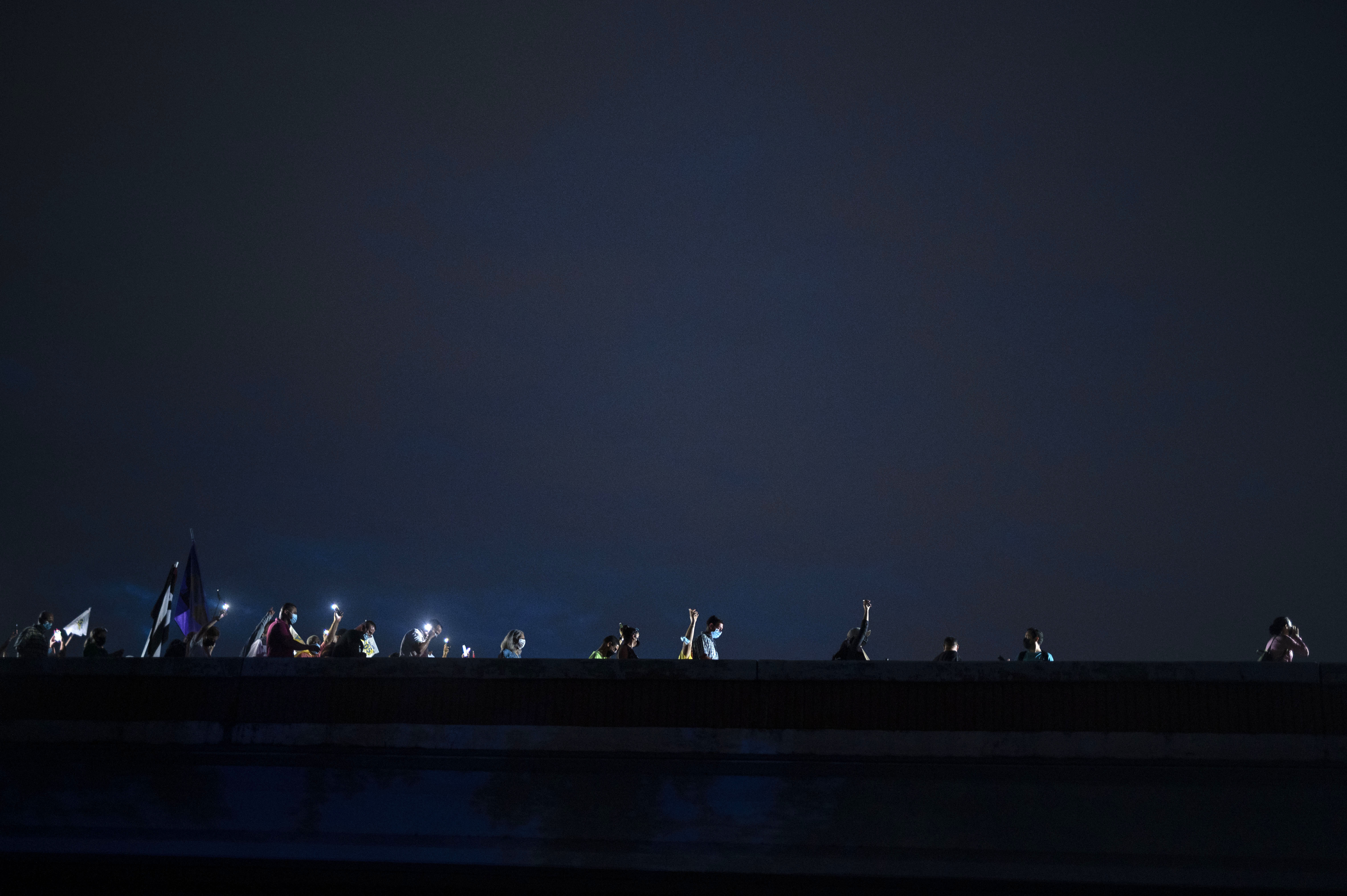 FILE - People march along Las Americas Highway to protest the LUMA Energy company in San Juan, Puerto Rico, Oct. 15, 2021. (AP Photo/Carlos Giusti, File)