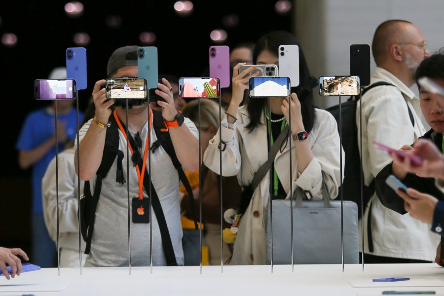 Attendees take a closer look at the Apple iPhone 16 during an announcement of new products at Apple headquarters Monday, Sept. 9, 2024, in Cupertino, Calif. (AP Photo/Juliana Yamada)