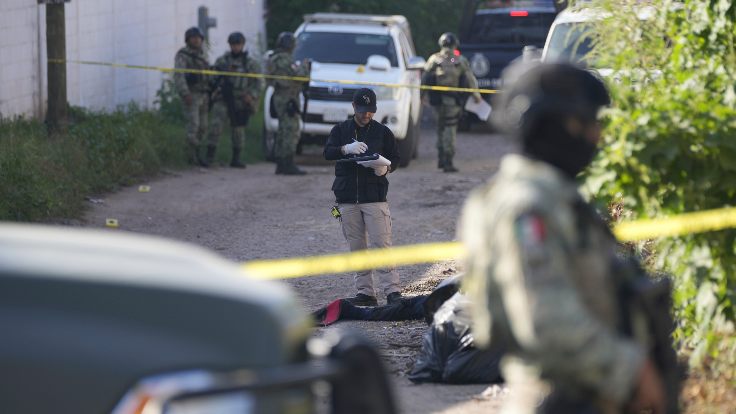 Forensic investigators work at the site of a body lying in the street in La Costerita, Culiacan, Sinaloa state, Mexico, Thursday, Sept. 19, 2024. (AP Photo/Eduardo Verdugo)