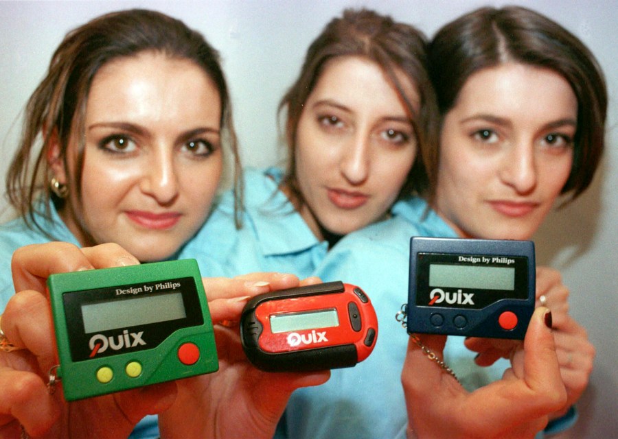 FILE - Three women hold the pager 'Quix' as they present it at CeBIT '97 in Hannover, Germany, Tuesday March 18, 1997. The beep-beep-beep of a small black box on your belt or in your pocket was something of a status symbol decades before the smartphone wiped it from popular culture. (AP Photo/Fabian Bimmer, File)