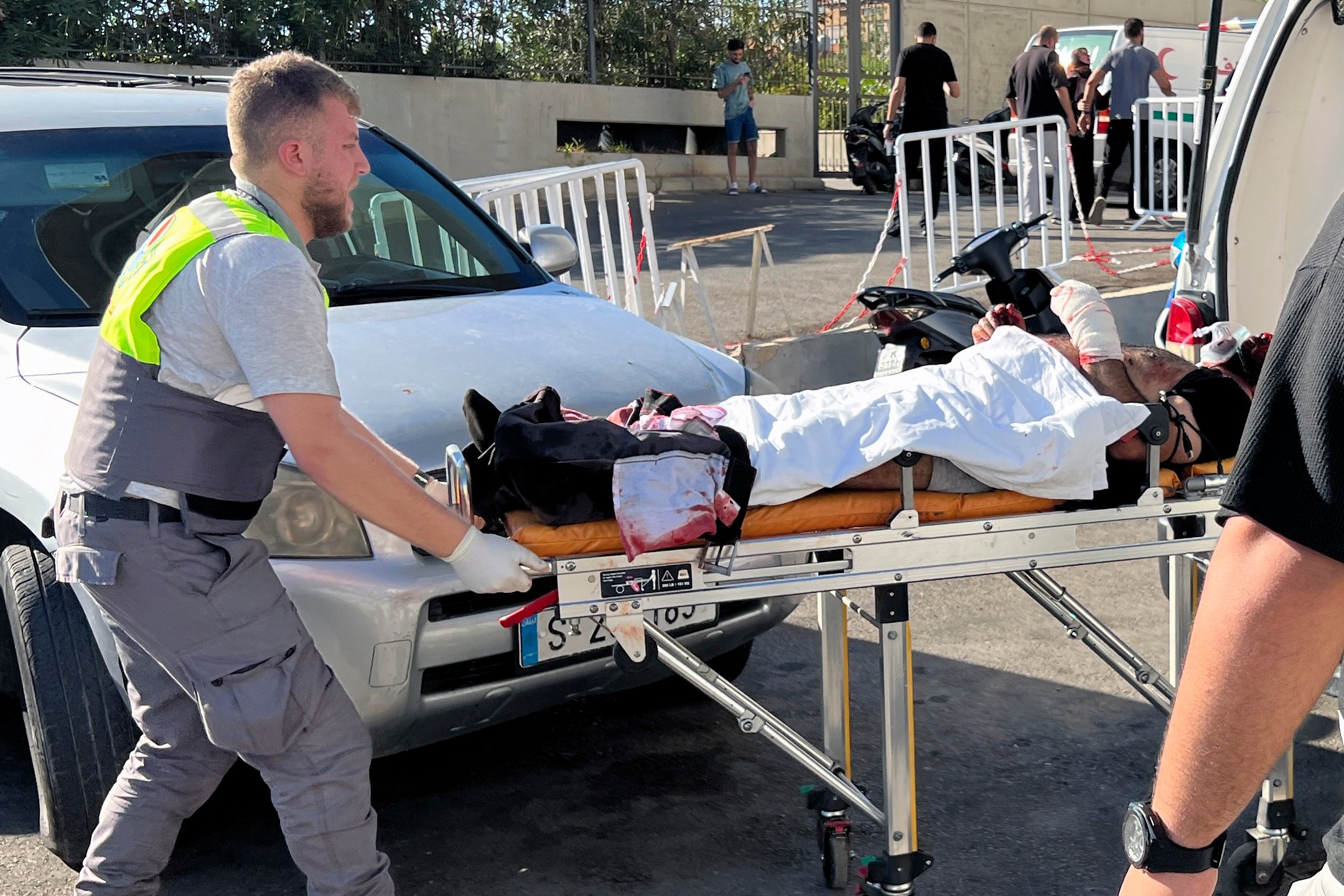 FILE - A Civil Defense first-responder carries a wounded man whose handheld pager exploded at al-Zahraa hospital in Beirut, on Sept. 17, 2024. (AP Photo/Hussein Malla, File)