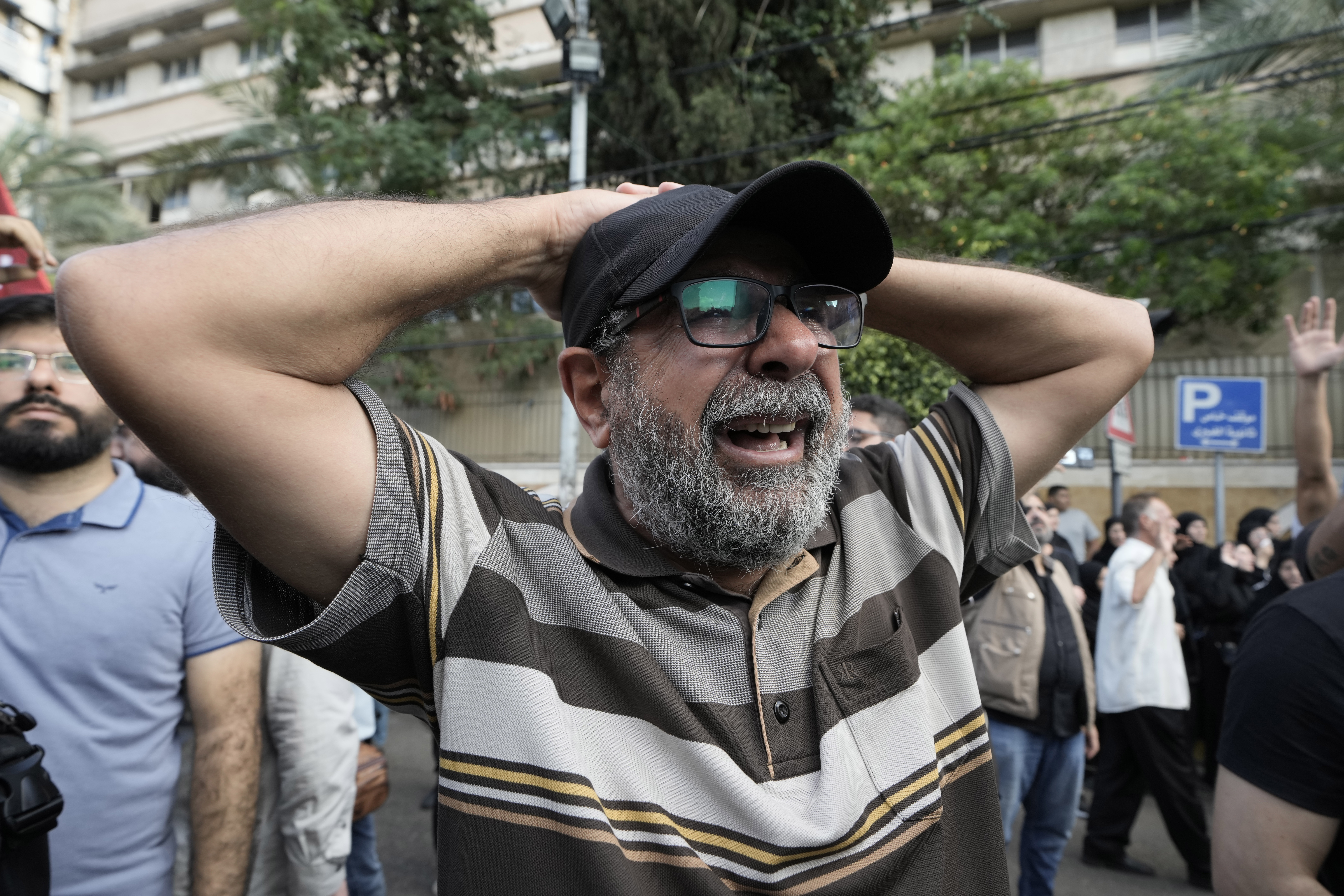 A man mourns during the funeral procession of Hezbollah members who were killed in Friday's Israeli strike, in the southern suburb of Beirut, Saturday, Sept. 21, 2024. (AP Photo/Bilal Hussein)